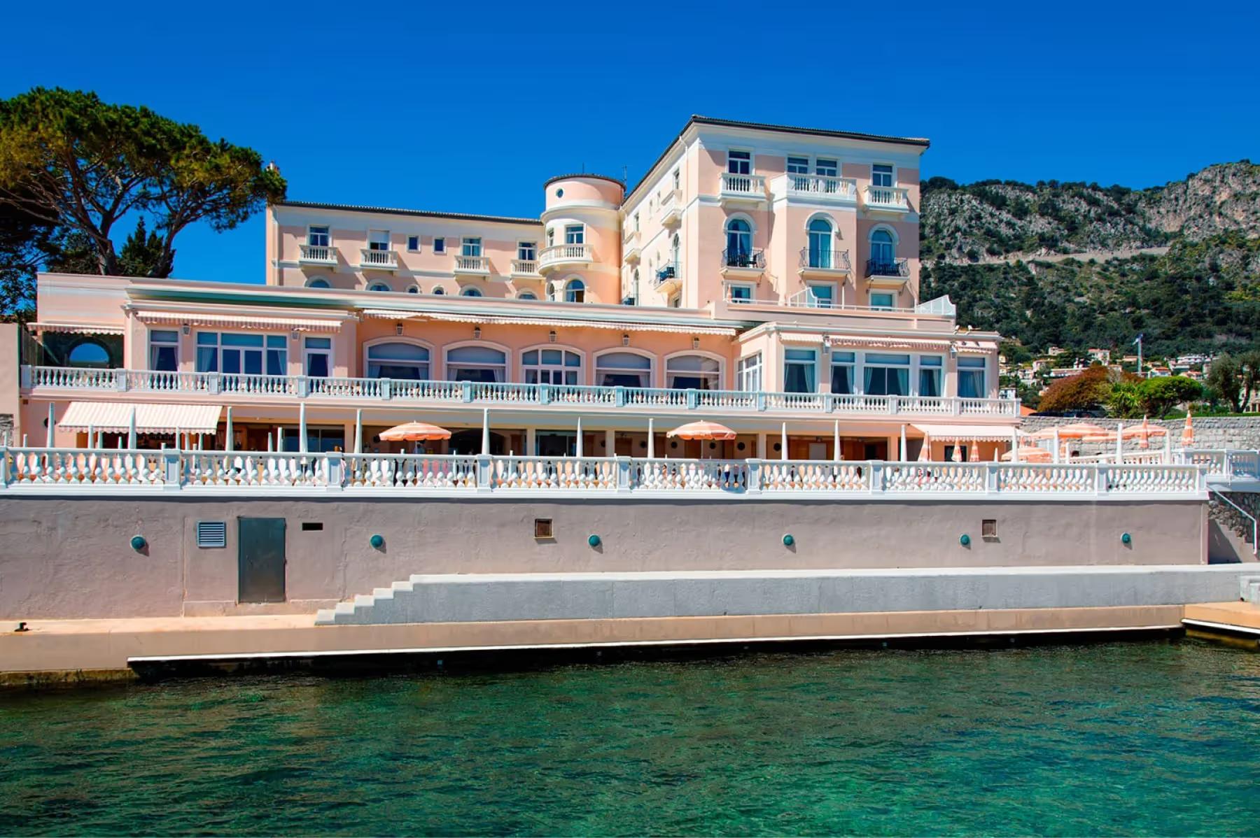 La Réserve de Beaulieu: pale stone facade of the historic hotel at waterfront with sailboats anchored nearby
