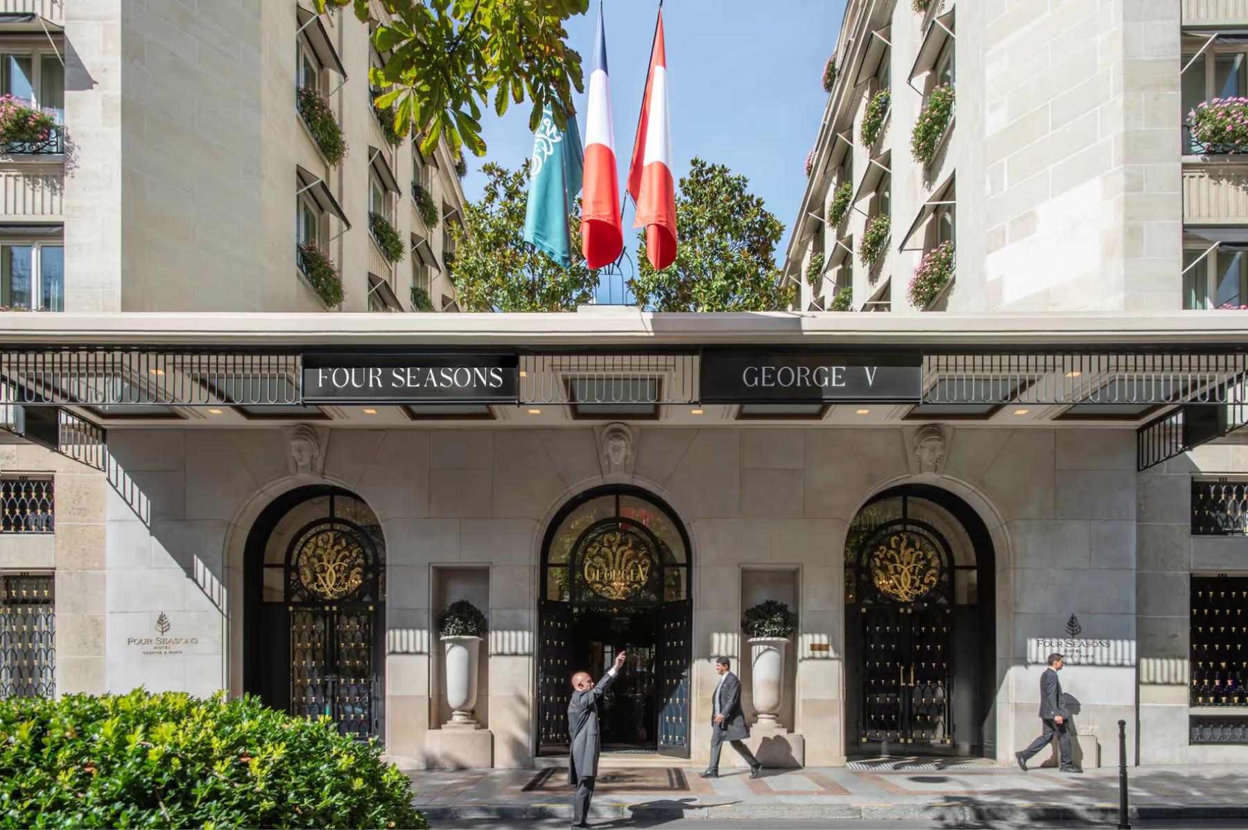 Four Seasons Hotel George V: the grand entrance facade with three rounded archways and tourists at street level