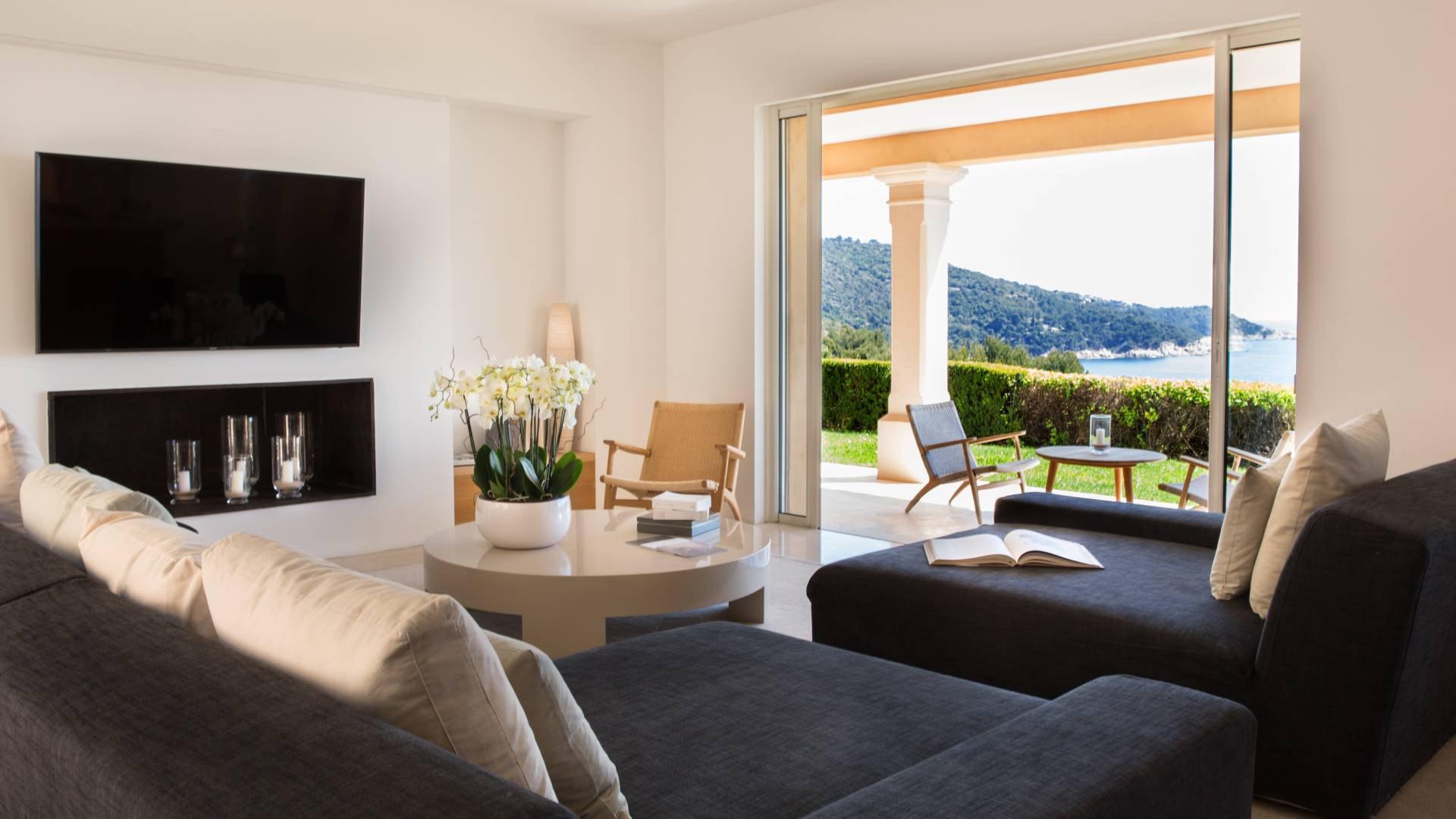 La Réserve Ramatuelle: bedroom with dark blue cushions and mountain views through glass doors
