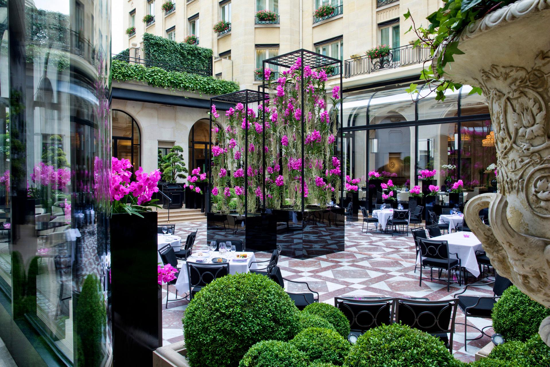Four Seasons Hotel George V: a grand restaurant room with ornate chandelier, cream walls, and a patterned marble floor
