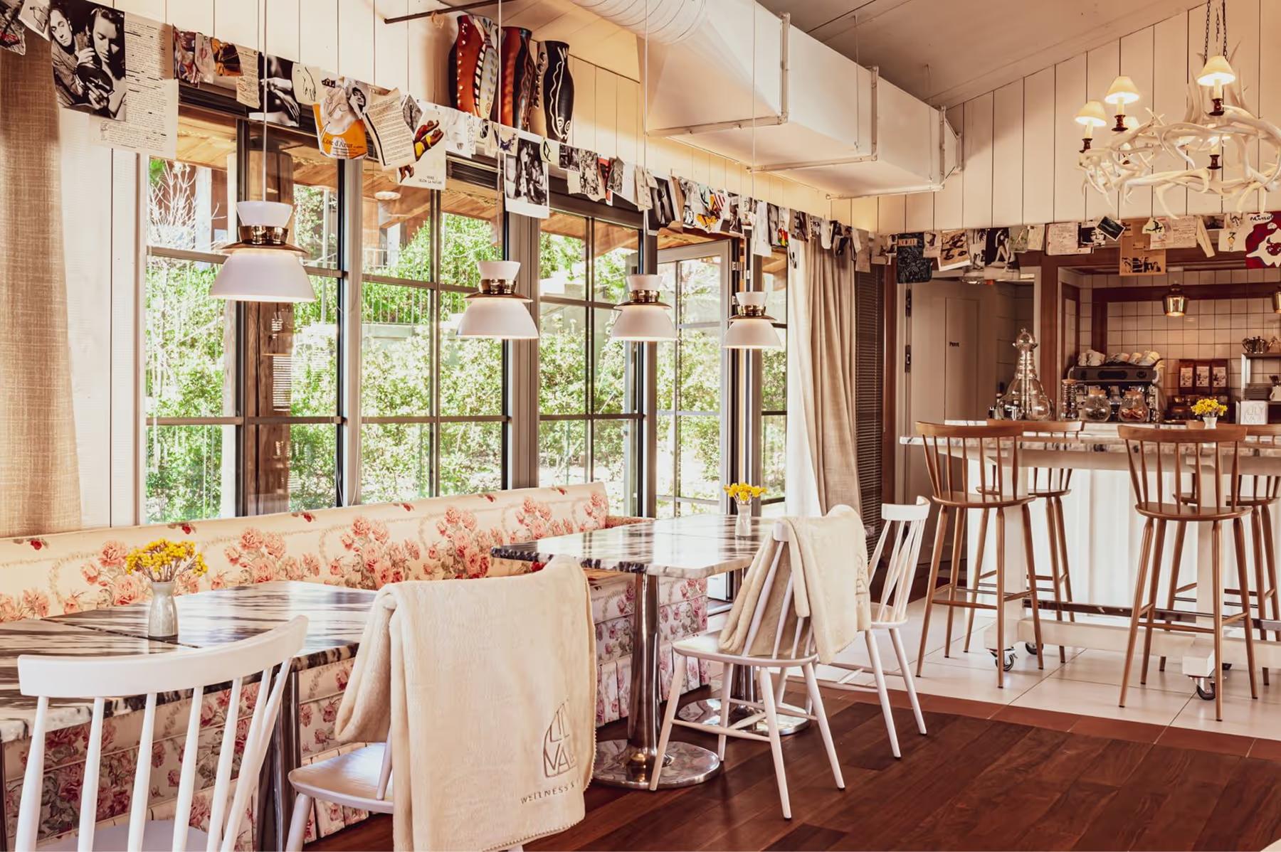 Dining room with large windows, pendant lights, and wooden bar stools