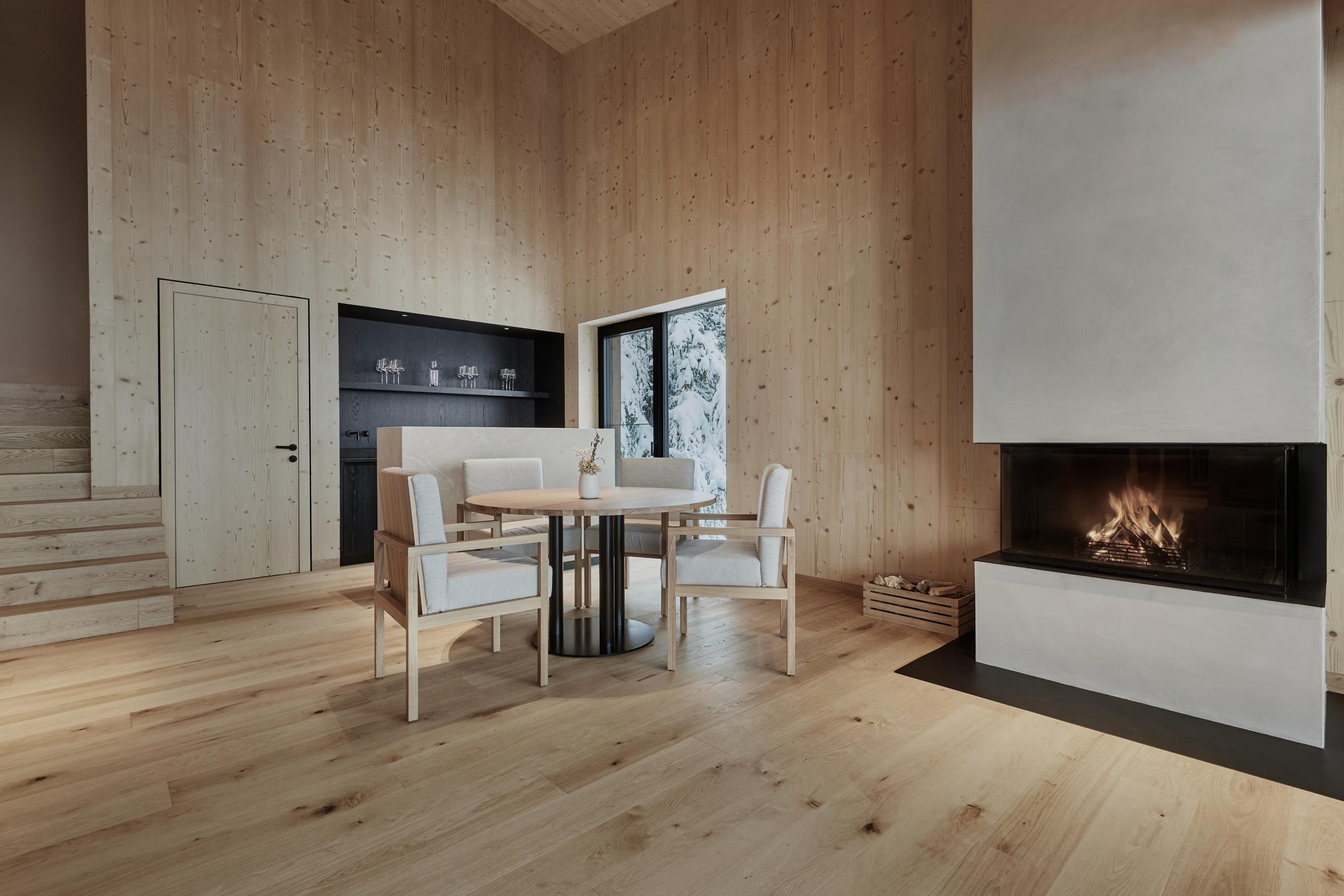Forestis: a residential space with neutral furnishings, natural wood accents, and ambient side lighting