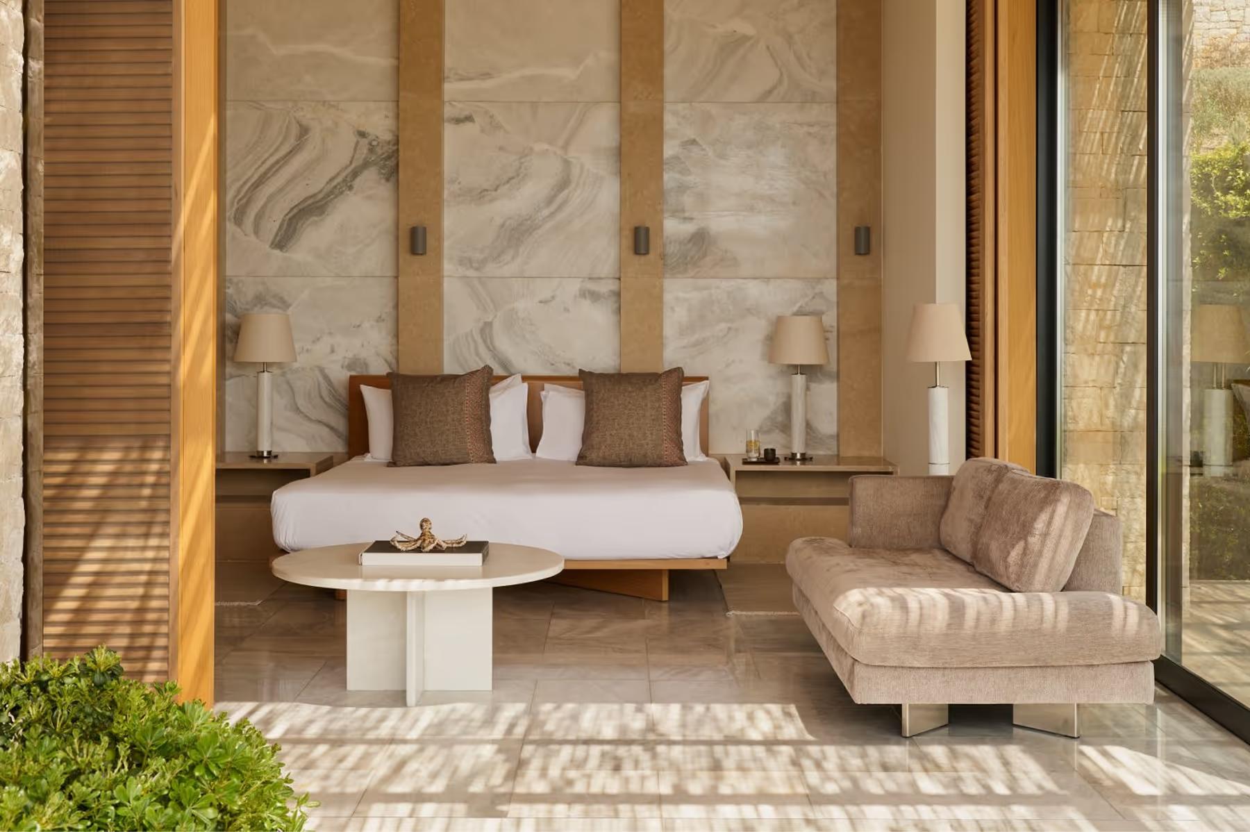 Pavilion bedroom with oversized marble headwall and neutral furnishings