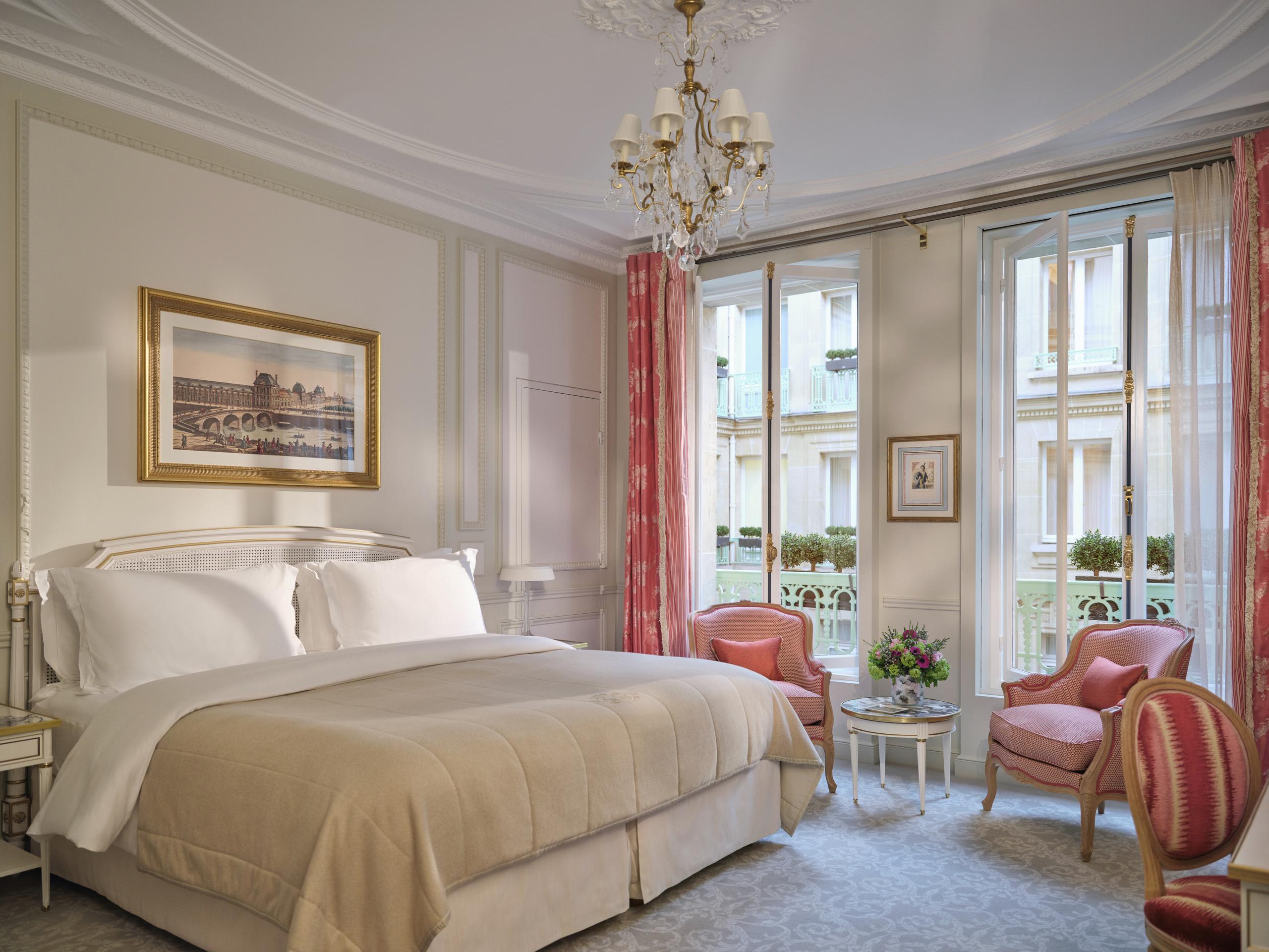 Le Meurice: a bedroom with queen bed, cream upholstery, traditional furnishings, and windows with red drapes