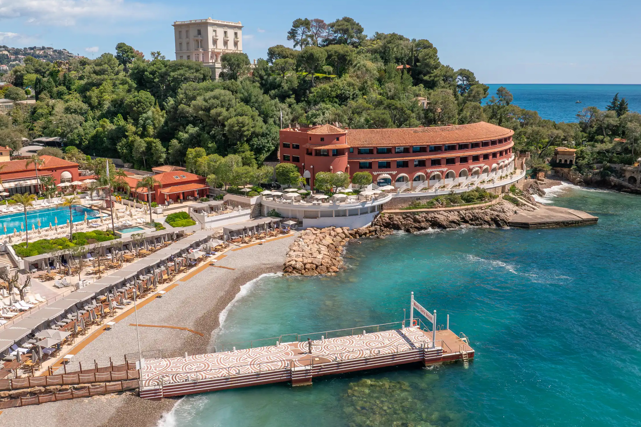 Coastal resort and spa facilities with red-roofed buildings and boat pier