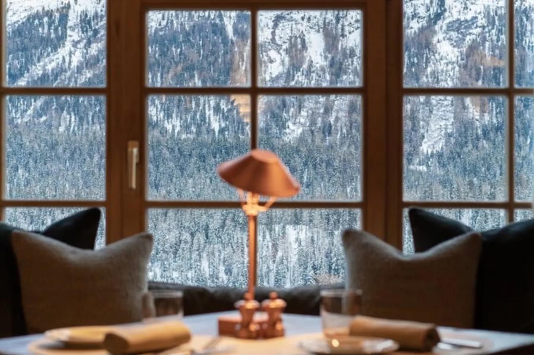 Kulm Hotel St. Moritz: a bartender pours a drink at the hotel bar with warm lighting and amber tones