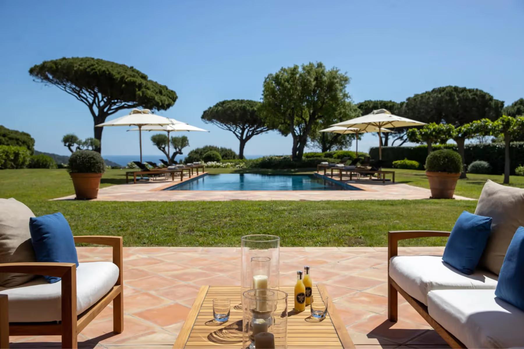 La Réserve Ramatuelle: pool terrace with Mediterranean pines and lounge seating area