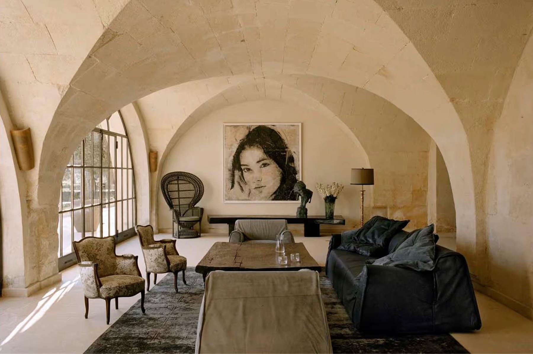 Vaulted limestone interior with barrel ceiling and simple furnishings in neutral tones