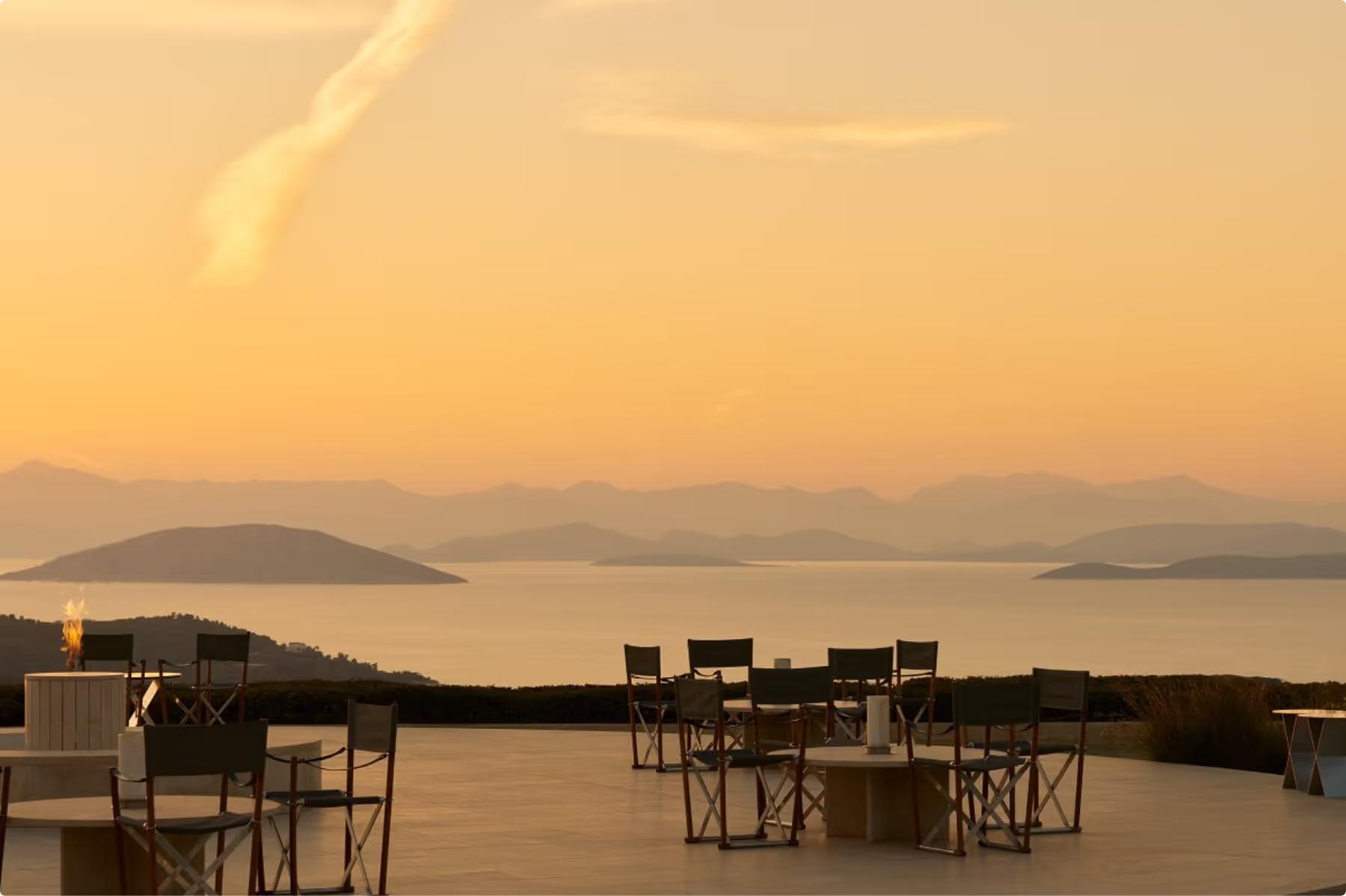 Amanzoe: open-air terrace dinner at golden hour with seascape vista