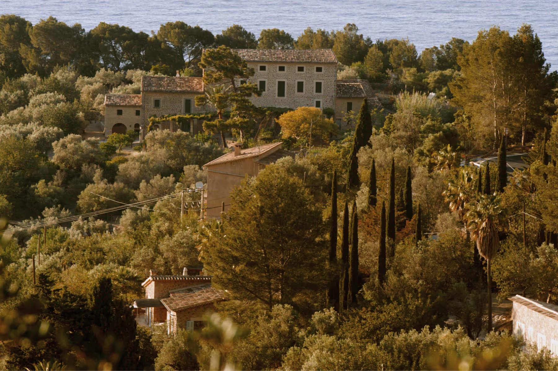 La Residencia: stone manor house surrounded by cypress trees and vegetation on a Mediterranean hillside