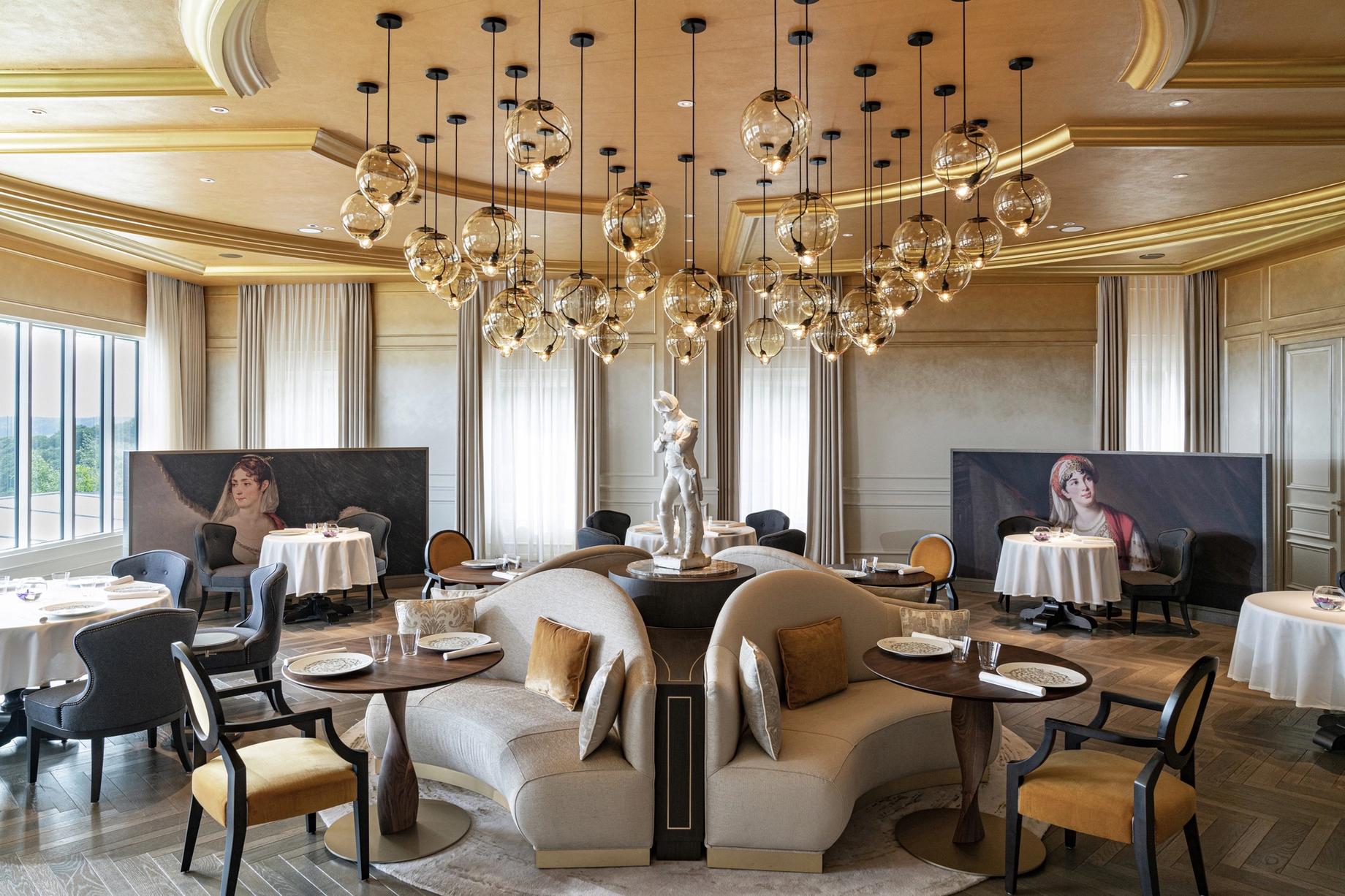 A dining room beneath cascading glass-globe lights in Champagne