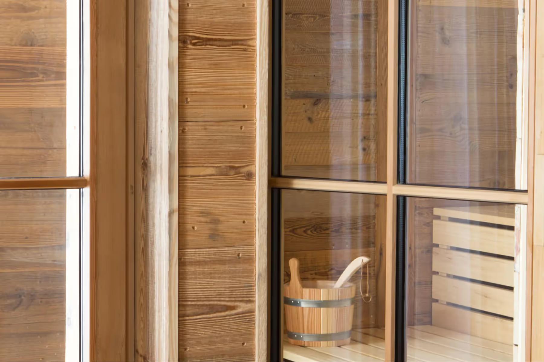 Wooden sauna interior with glass sliding doors