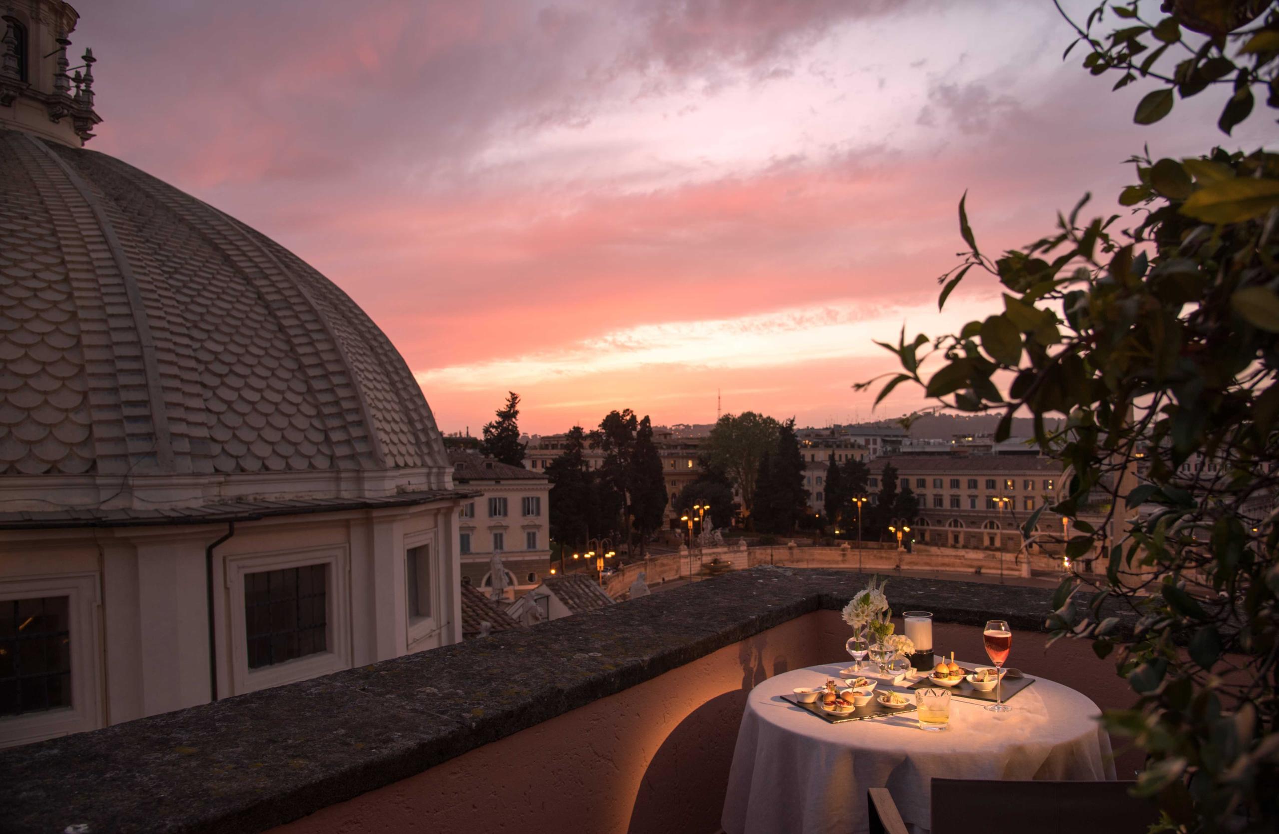 Hotel de Russie: rooftop table setting at sunset with dome visible and pink sky