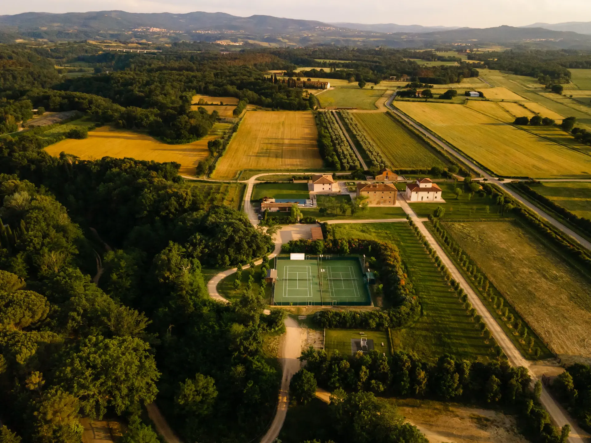 The tennis courts among vineyards and olive groves at Il Borro, seen from above