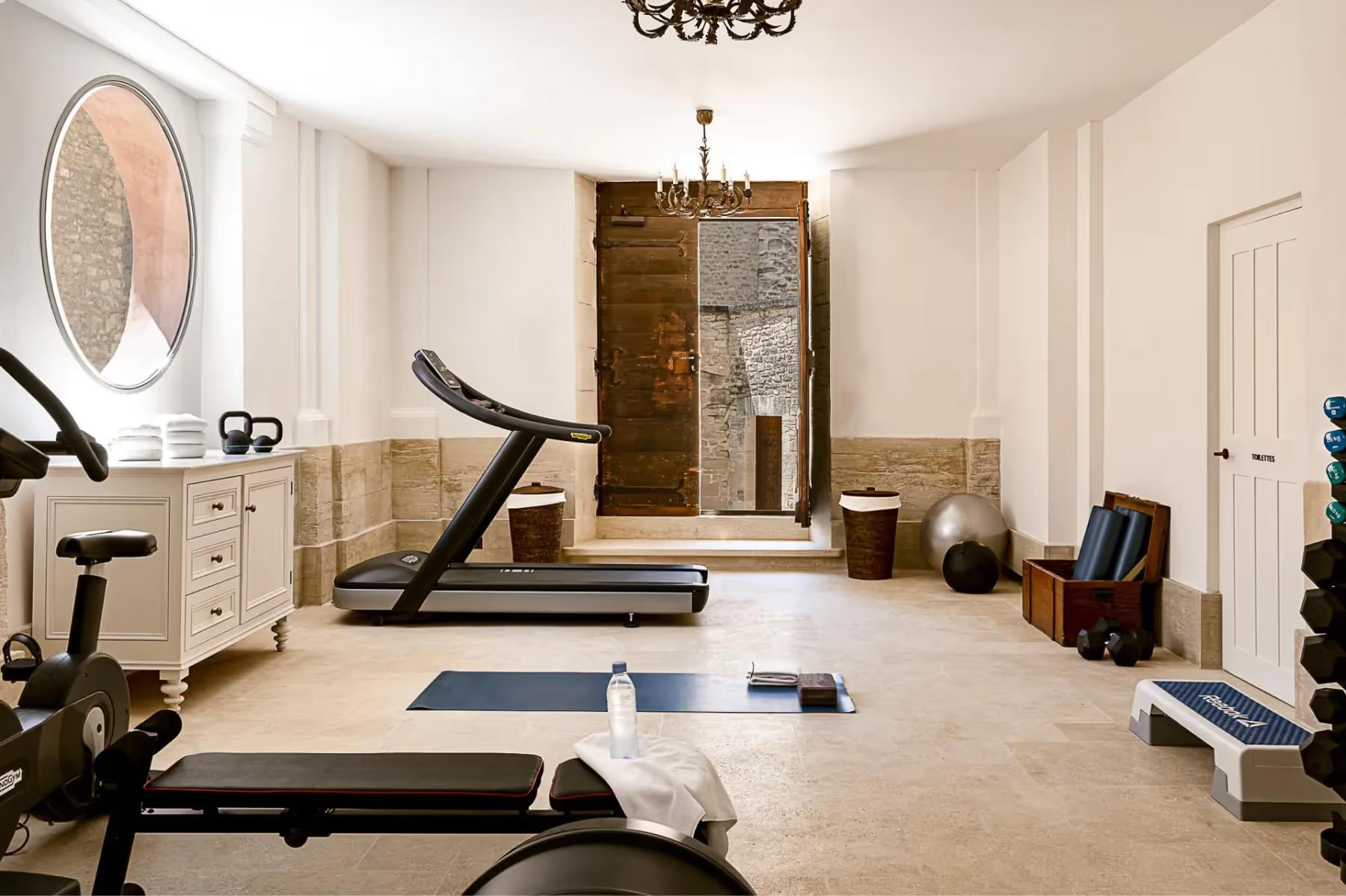 Hôtel Crillon le Brave: a bright gymnasium with exercise equipment, fitness machines, and a large window for natural light