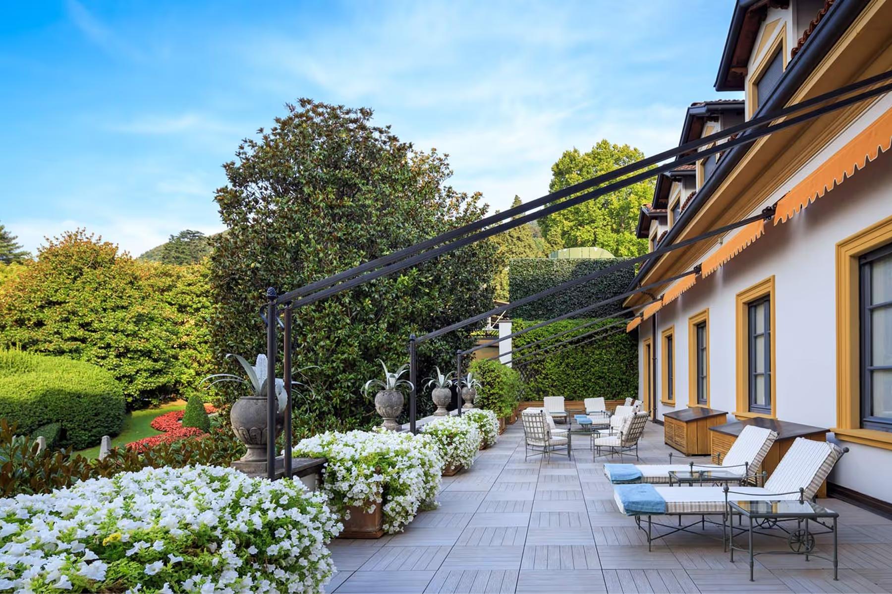 Villa d’Este: terraced garden area with lounging space among manicured green lawns and plants