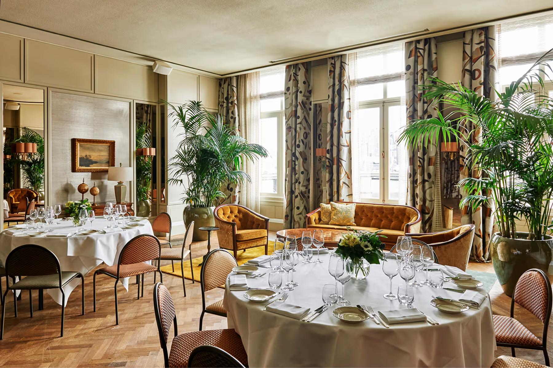 Private dining room with round table, crystal chandelier, and classical architecture