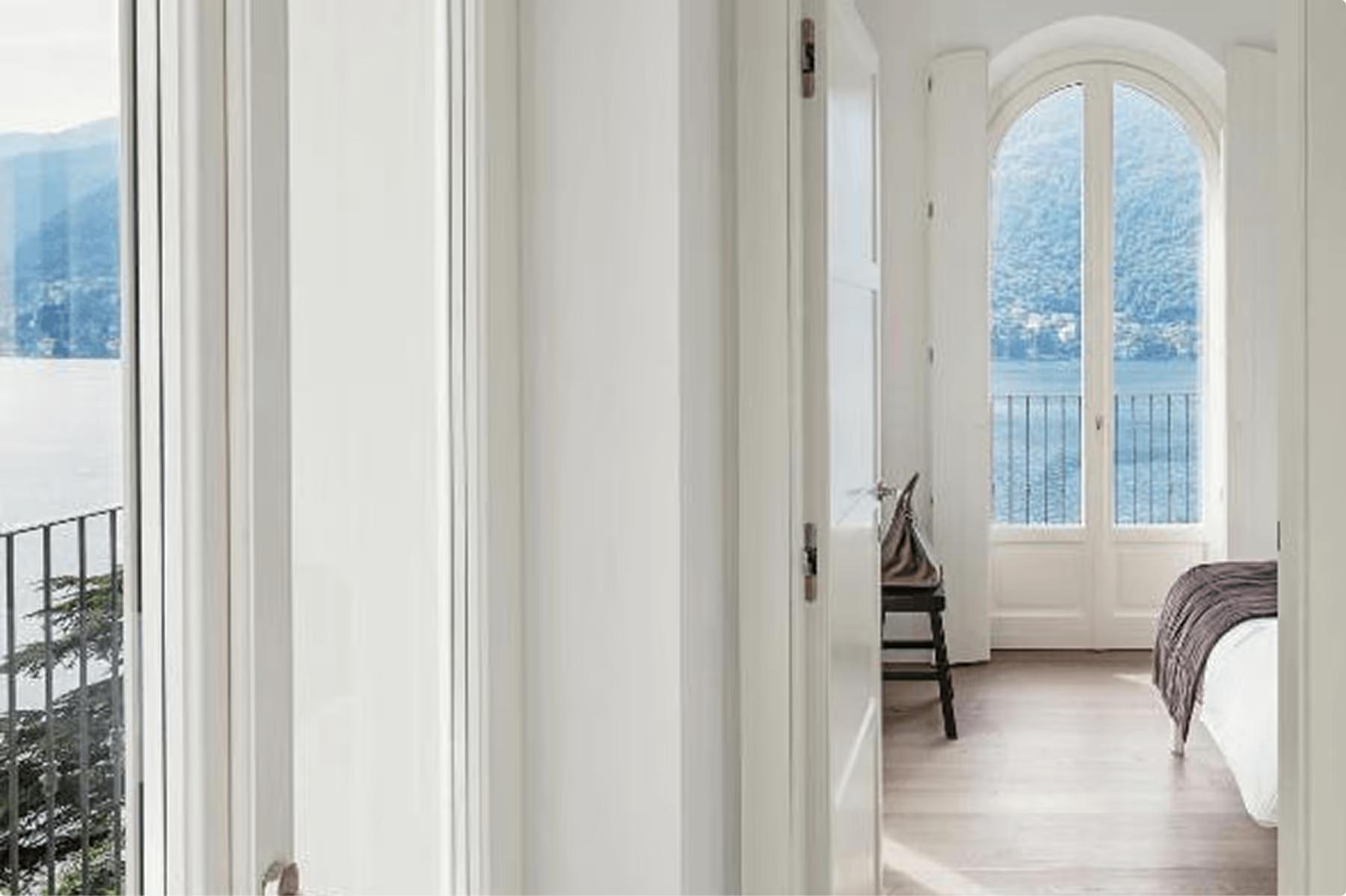 Bright hallway with tall arched doors opening to views of the lake