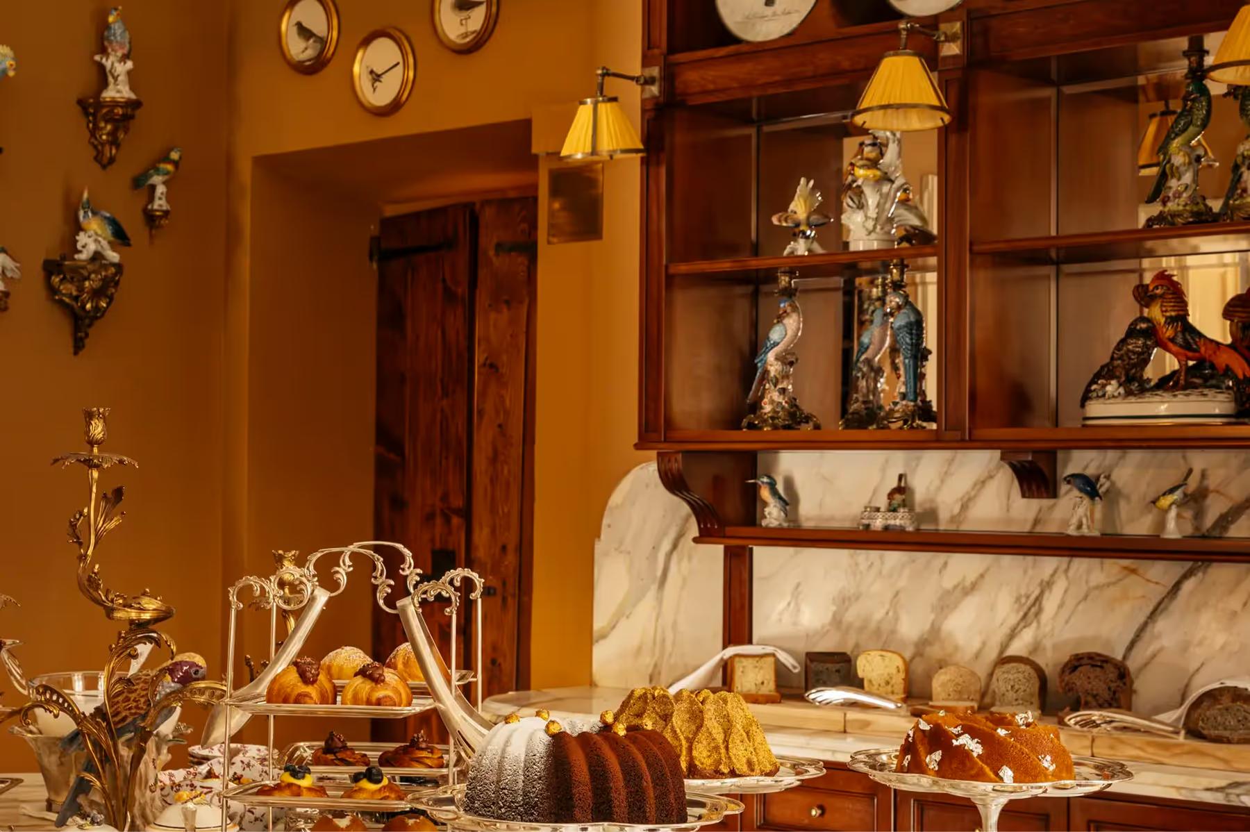 A formal dining room display with ornate shelving, candleabra, and fine ceramics