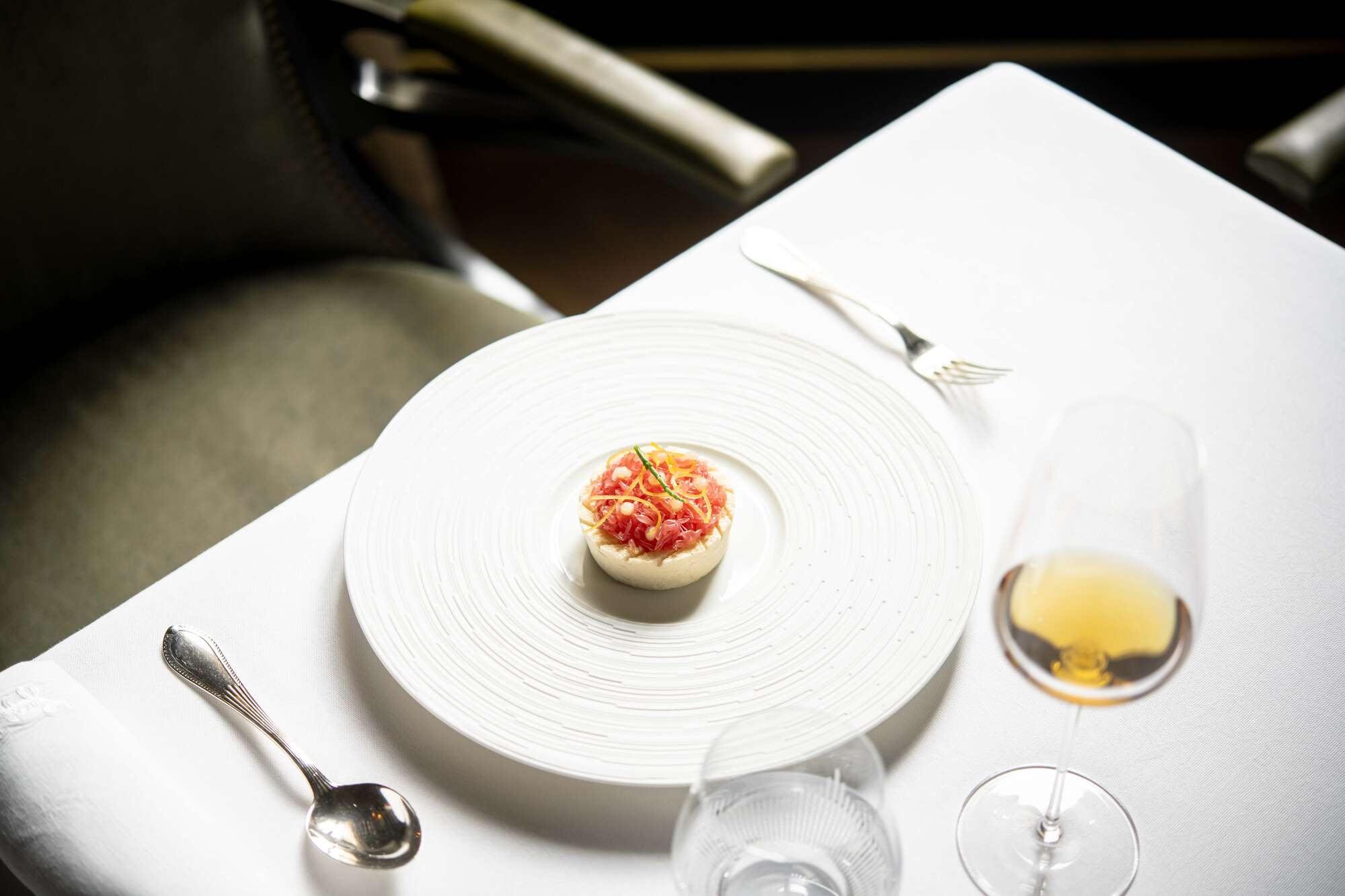 A delicate course with white wine and table settings in soft light