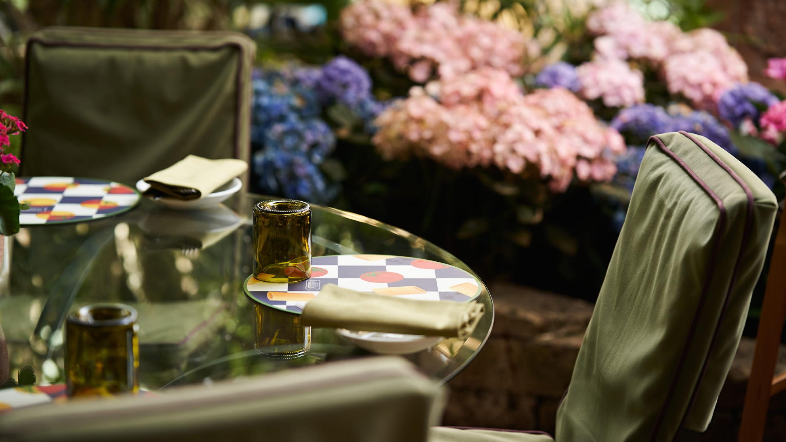 Four Seasons Hotel Firenze: table setting with wine glass and pink and blue hydrangea blooms in the background
