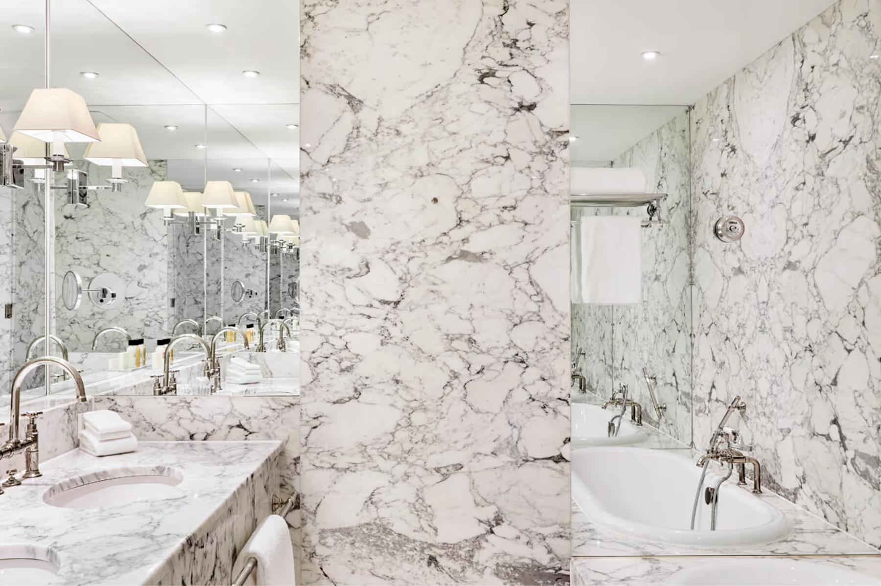 Marble bathroom with double vanity, soaking tub, and subway tile accent wall