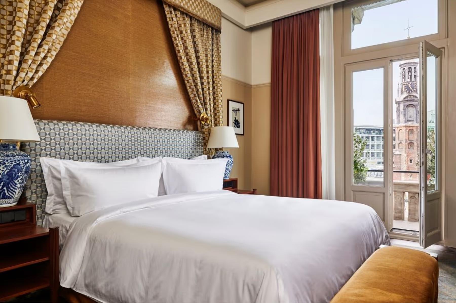 De L’Europe Amsterdam: suite bedroom with multiple seating areas and city views through large windows