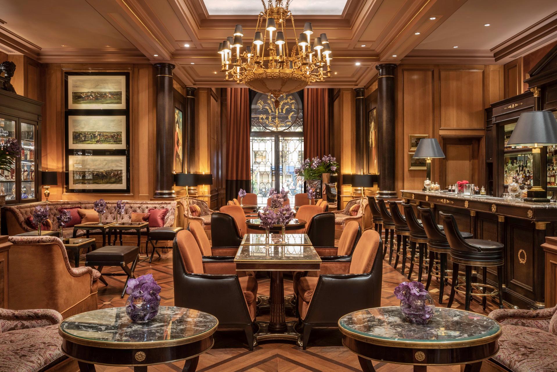 Four Seasons Hotel George V: a wood-lined lounge with burgundy chairs, coffee table, and small art gallery walls