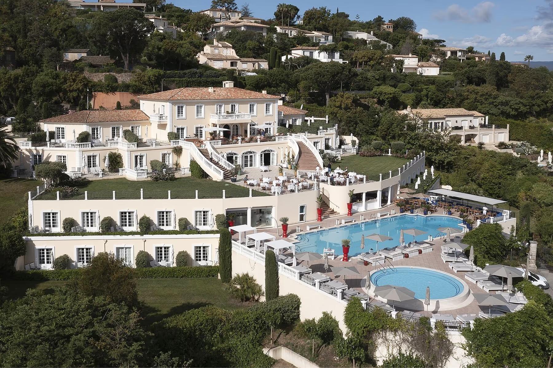 Althoff Villa Belrose: hilltop villa with white stone facade and swimming pools overlooking forested coastline