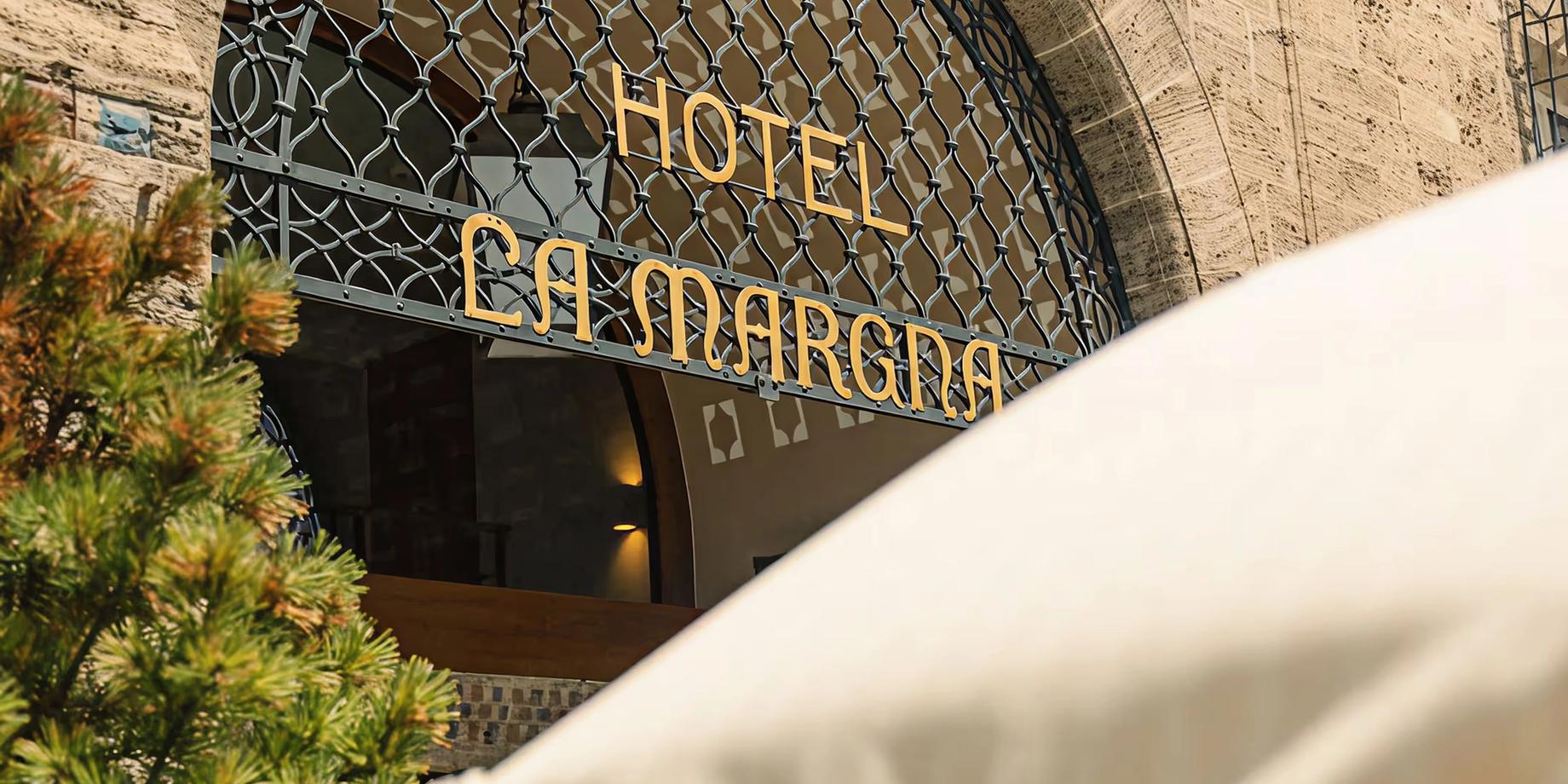 Grace La Margna St. Moritz: the arched entrance to Grace La Margna with the hotel name in gold lettering