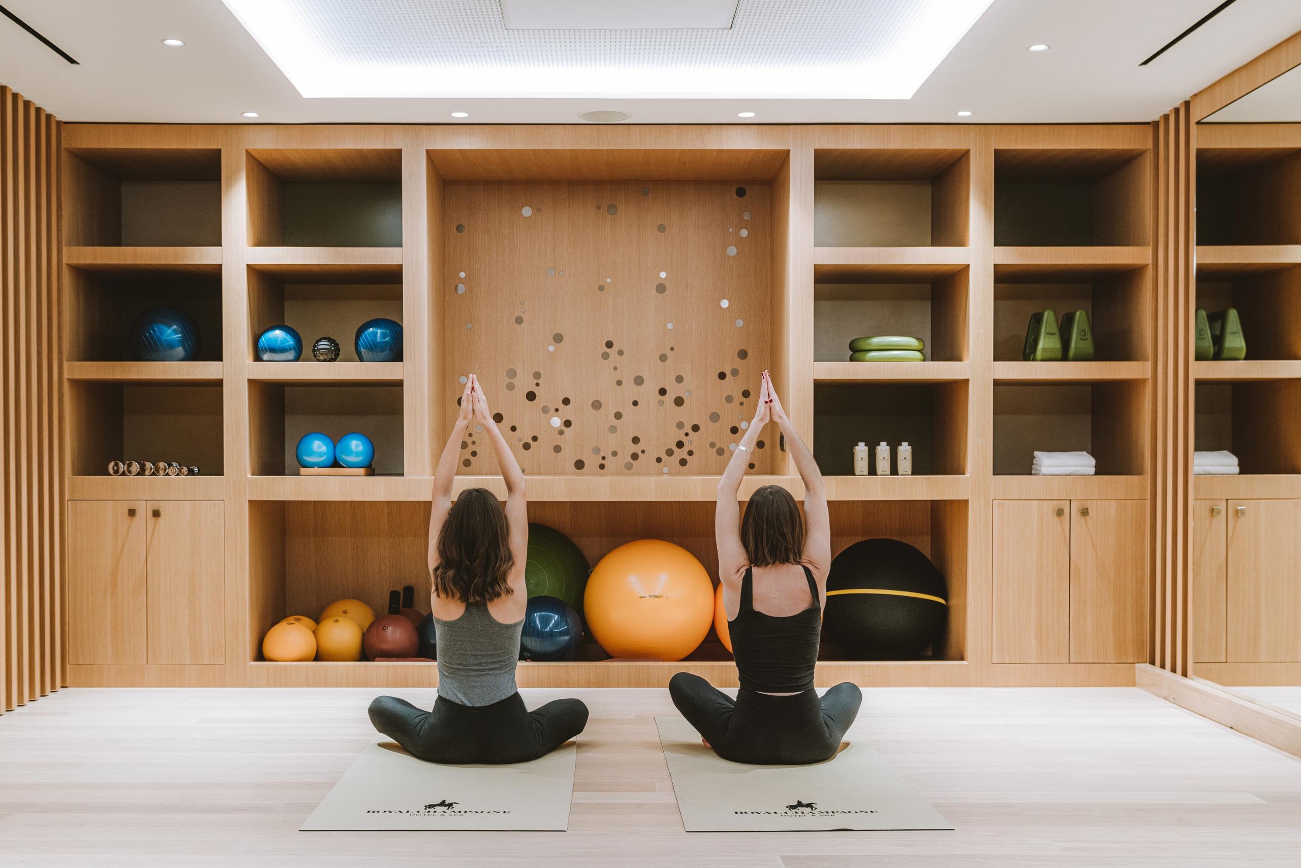Meditation room with floor cushions, natural wood shelving, and soft natural light