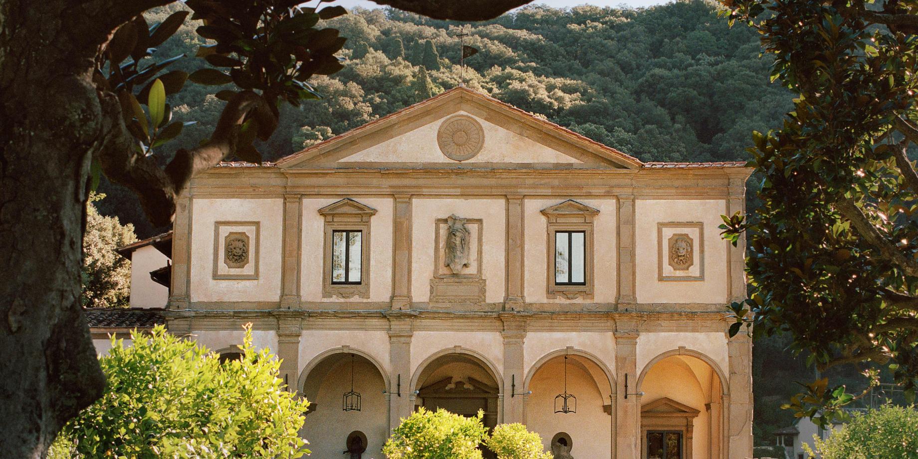 The Renaissance facade of Villa San Michele framed by magnolia trees, its arcade open to the gardens