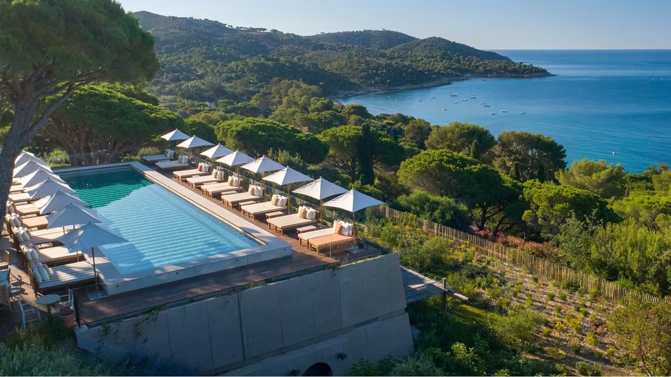 Pool with sun loungers overlooking the Mediterranean at dusk