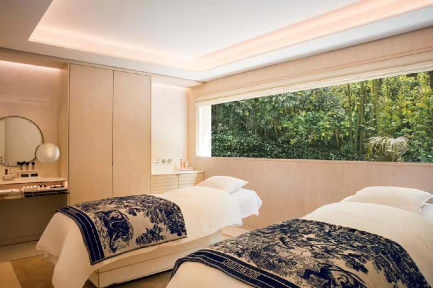 Hôtel du Cap-Eden-Roc: a spa treatment room with white linens, soft ambient lighting, and forest views