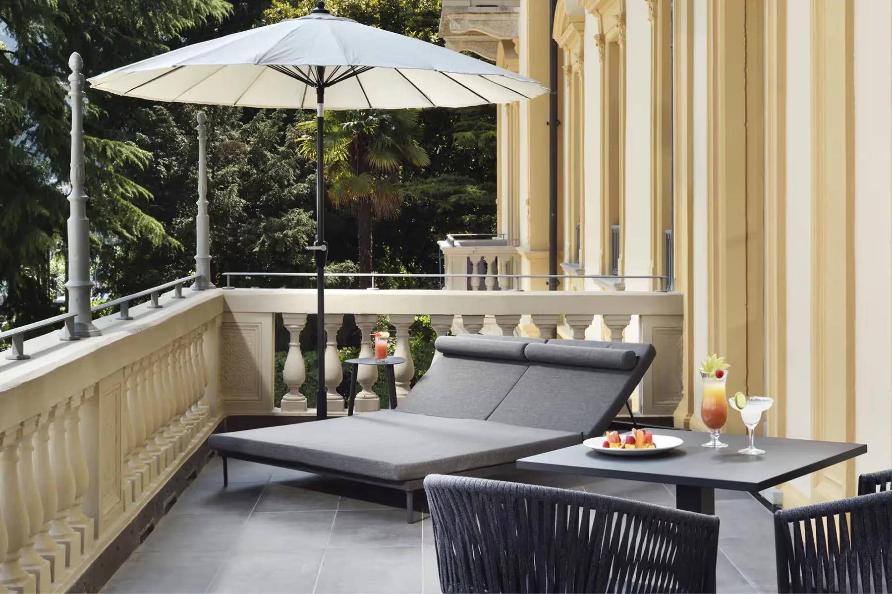 A terraced seating area with shade umbrellas overlooking the lake from a height