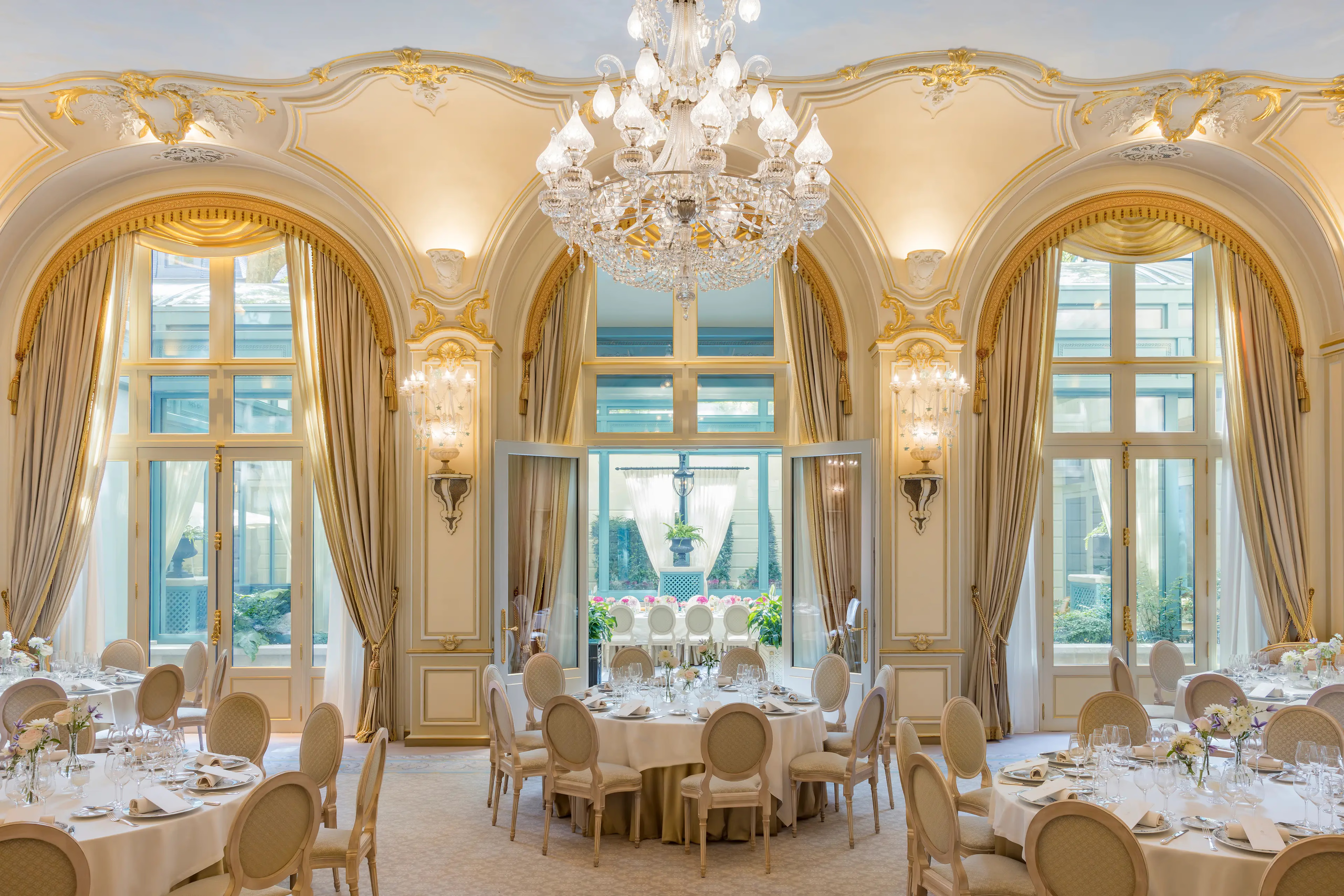 Ritz Paris: a dining room with gilt arches, crystal chandelier, and tables set for service