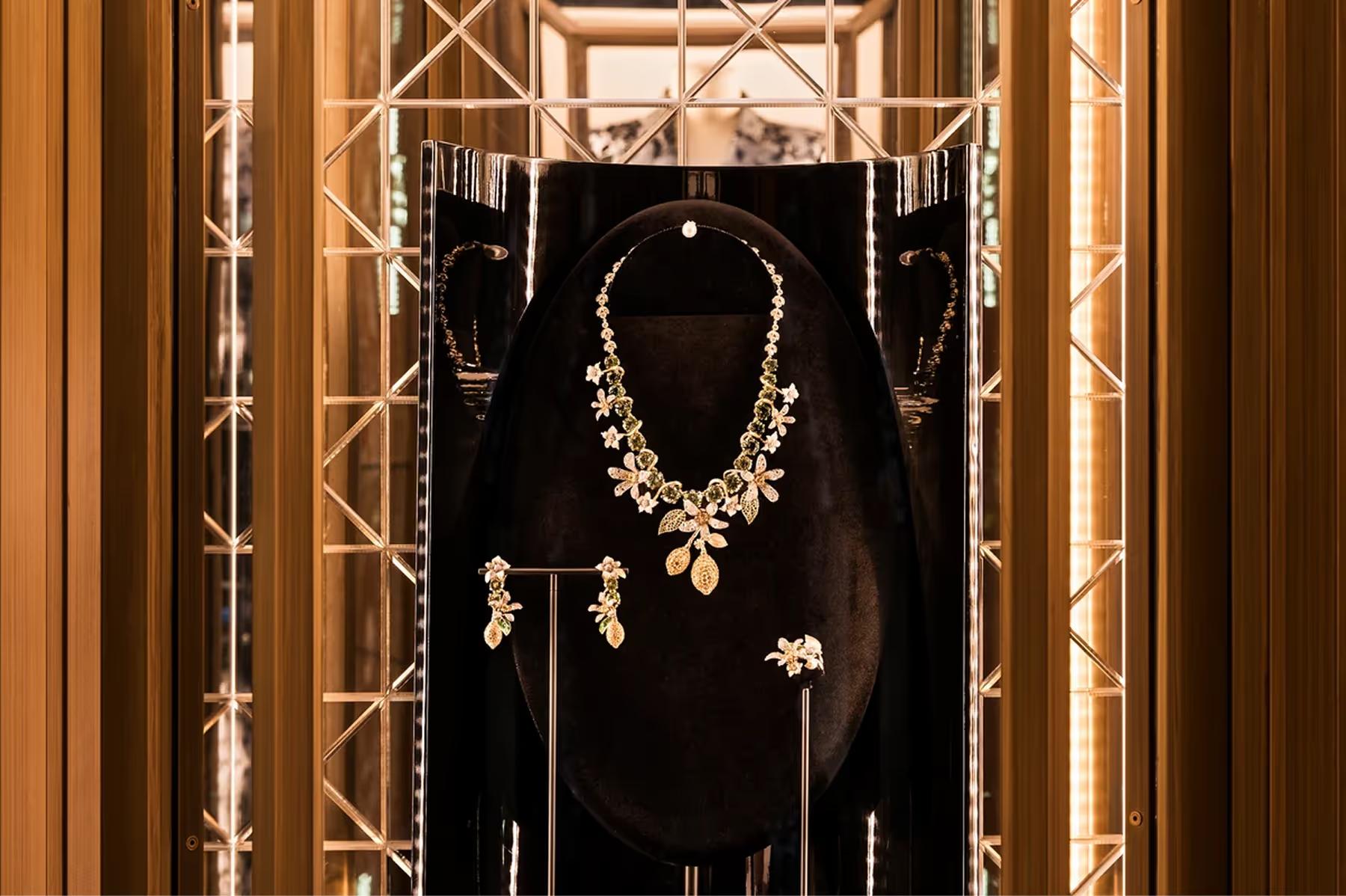 A jewelry display featuring an ornate gold necklace with matching earrings
