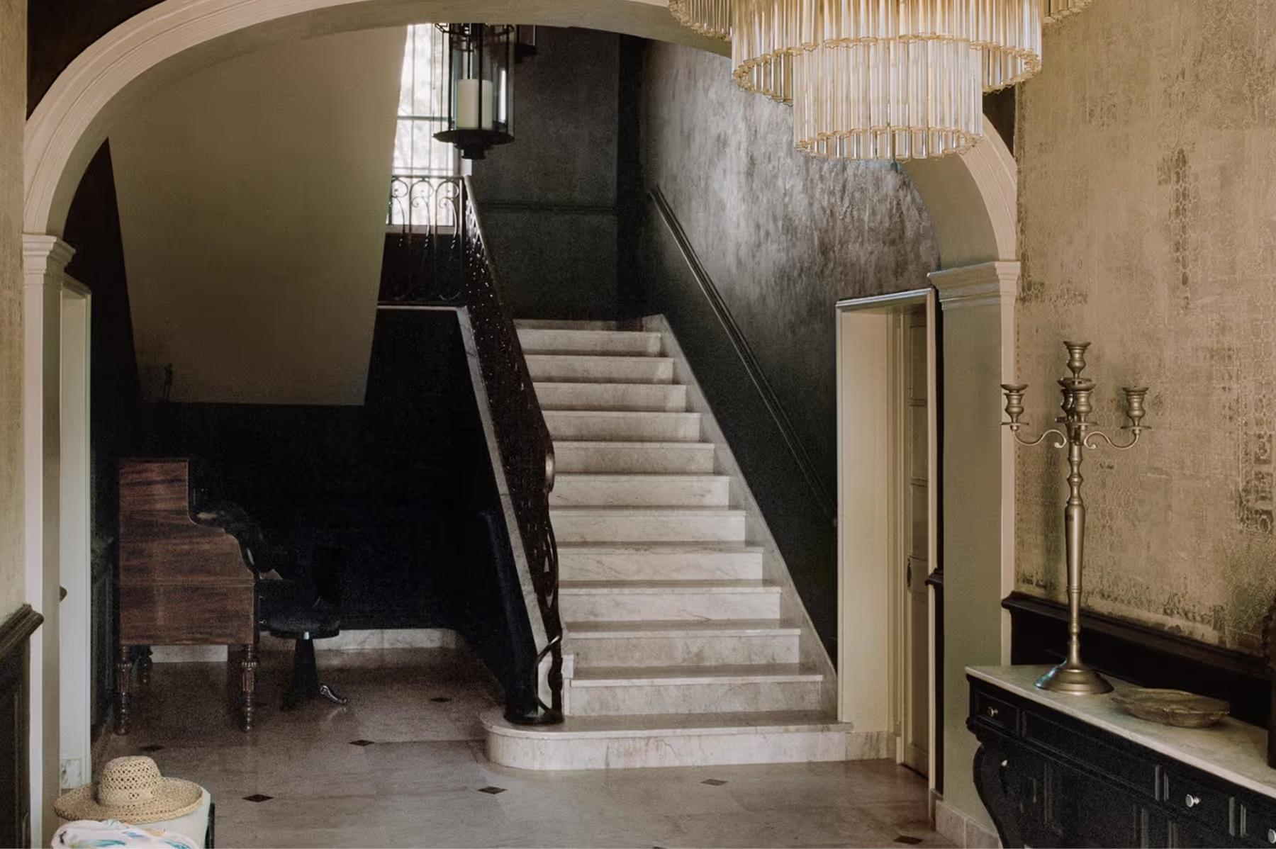 Le Mas de Chabran: barrel-vaulted stone hall with staircase, glass pendant, and minimalist modern furnishings
