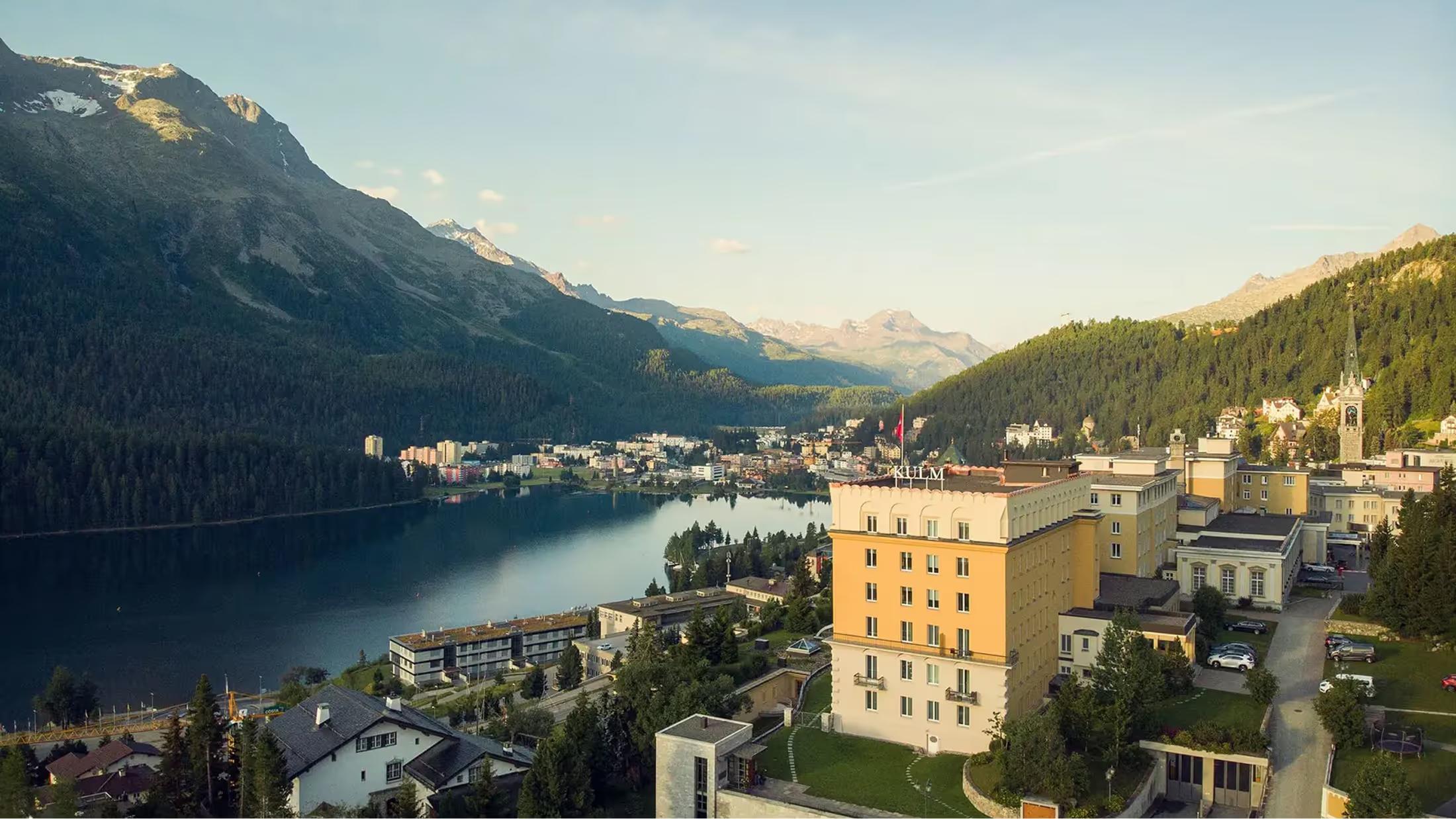 The hotel’s honey-colored facade overlooks Lake St. Moritz with Alpine peaks beyond