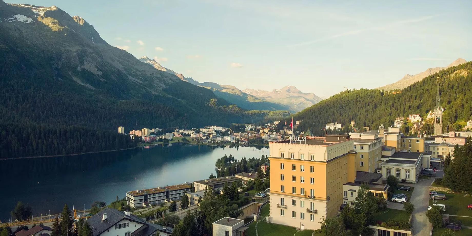 The hotel’s honey-colored facade overlooks Lake St. Moritz with Alpine peaks beyond