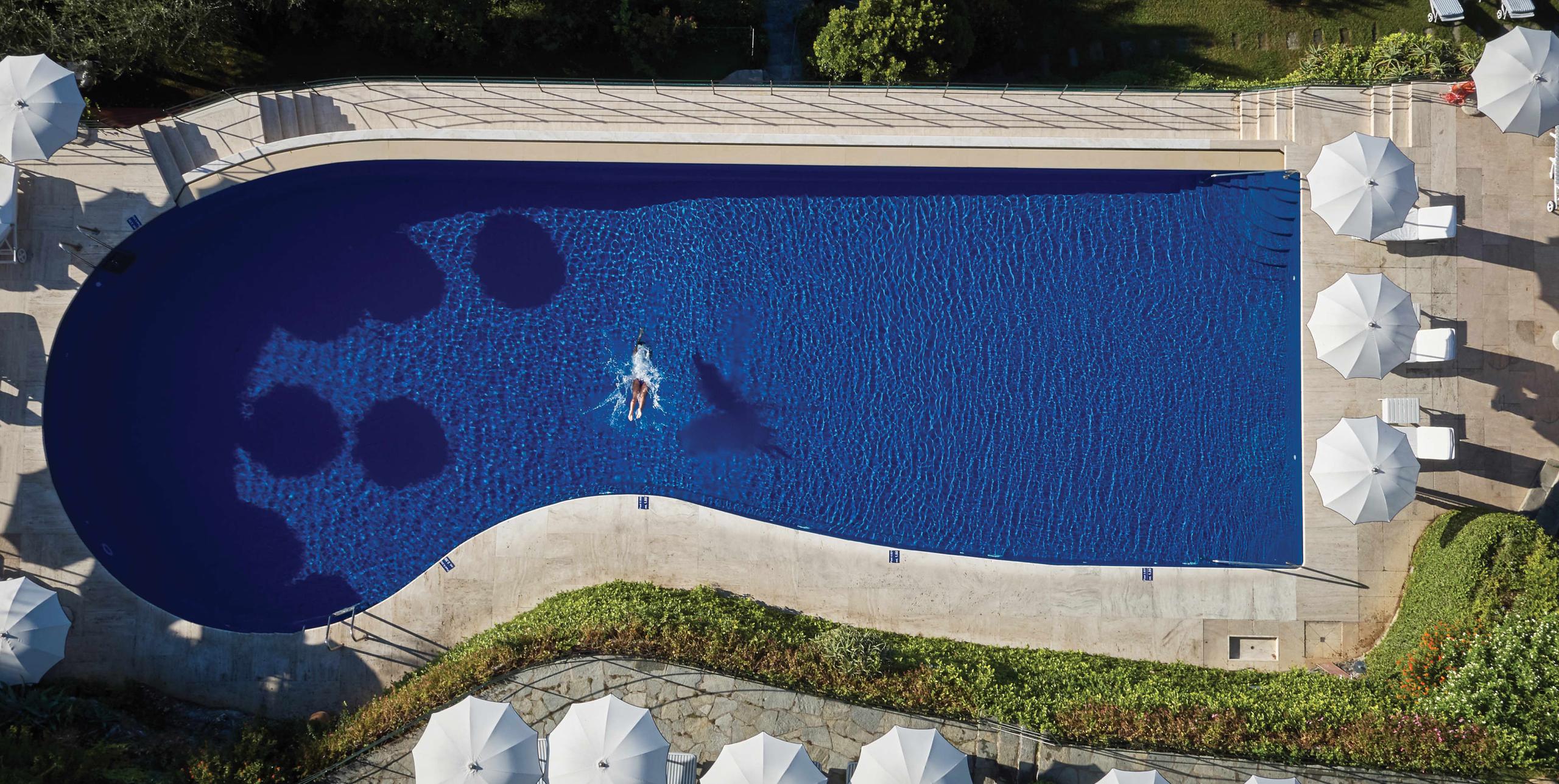 Splendido: an aerial view of the infinity pool surrounded by white loungers and emerald water