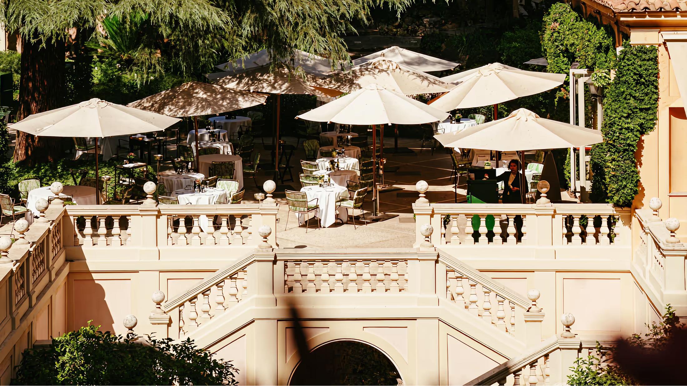 Tiered garden terrace with cream-colored umbrellas overlooking Rome
