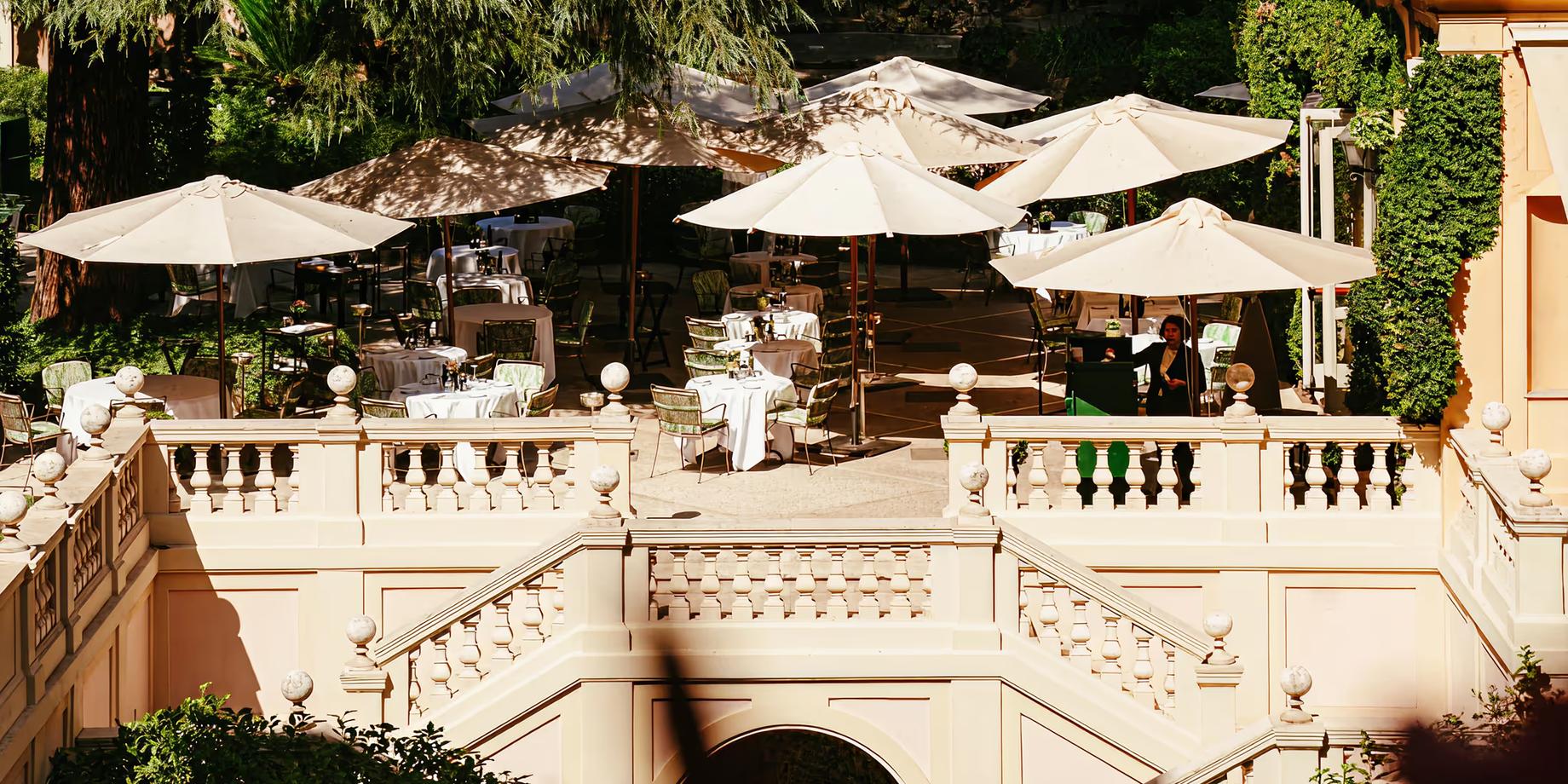 Tiered garden terrace with cream-colored umbrellas overlooking Rome