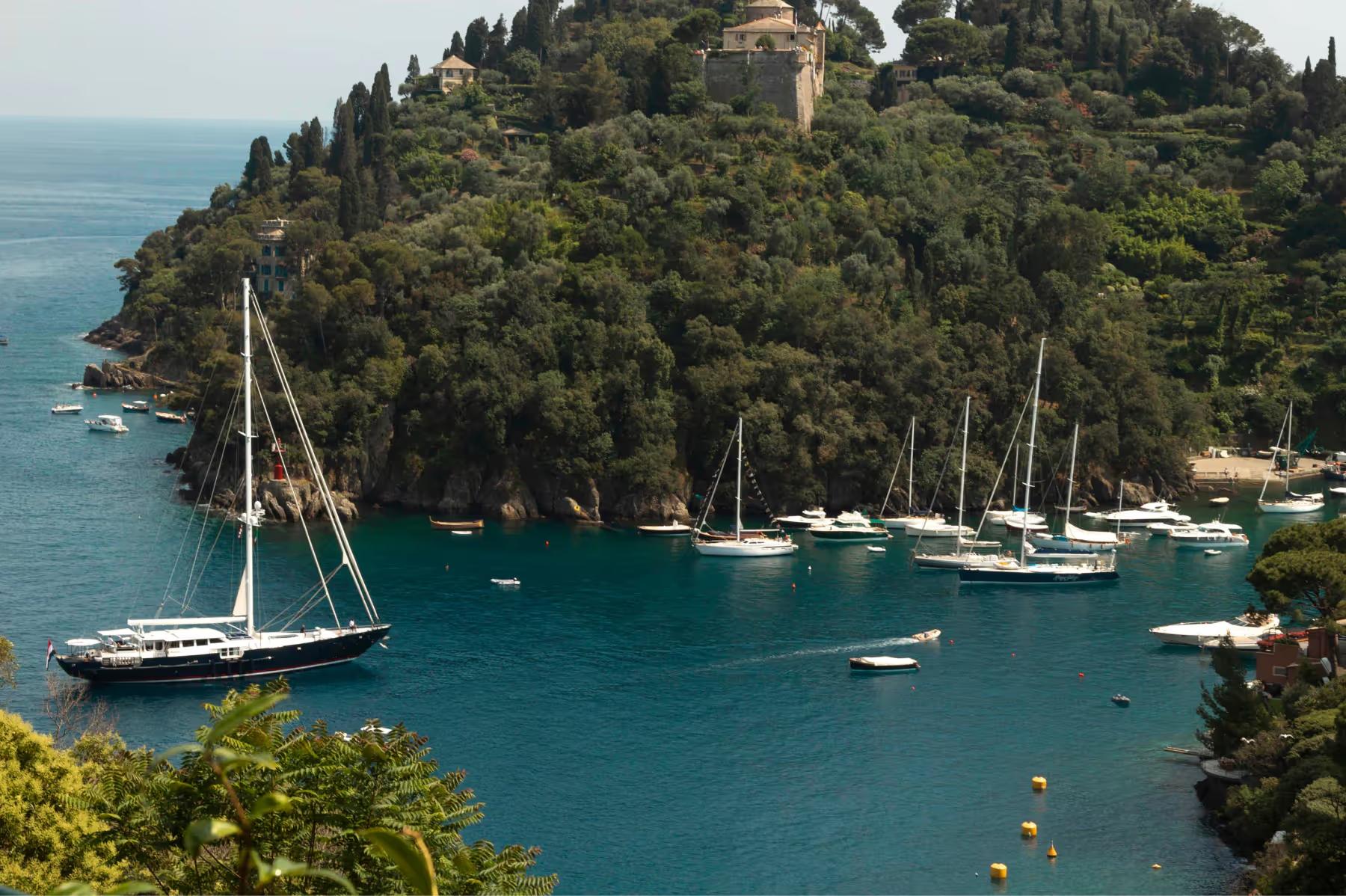 Aerial view of a secluded cove with sailboats and white beach club structures