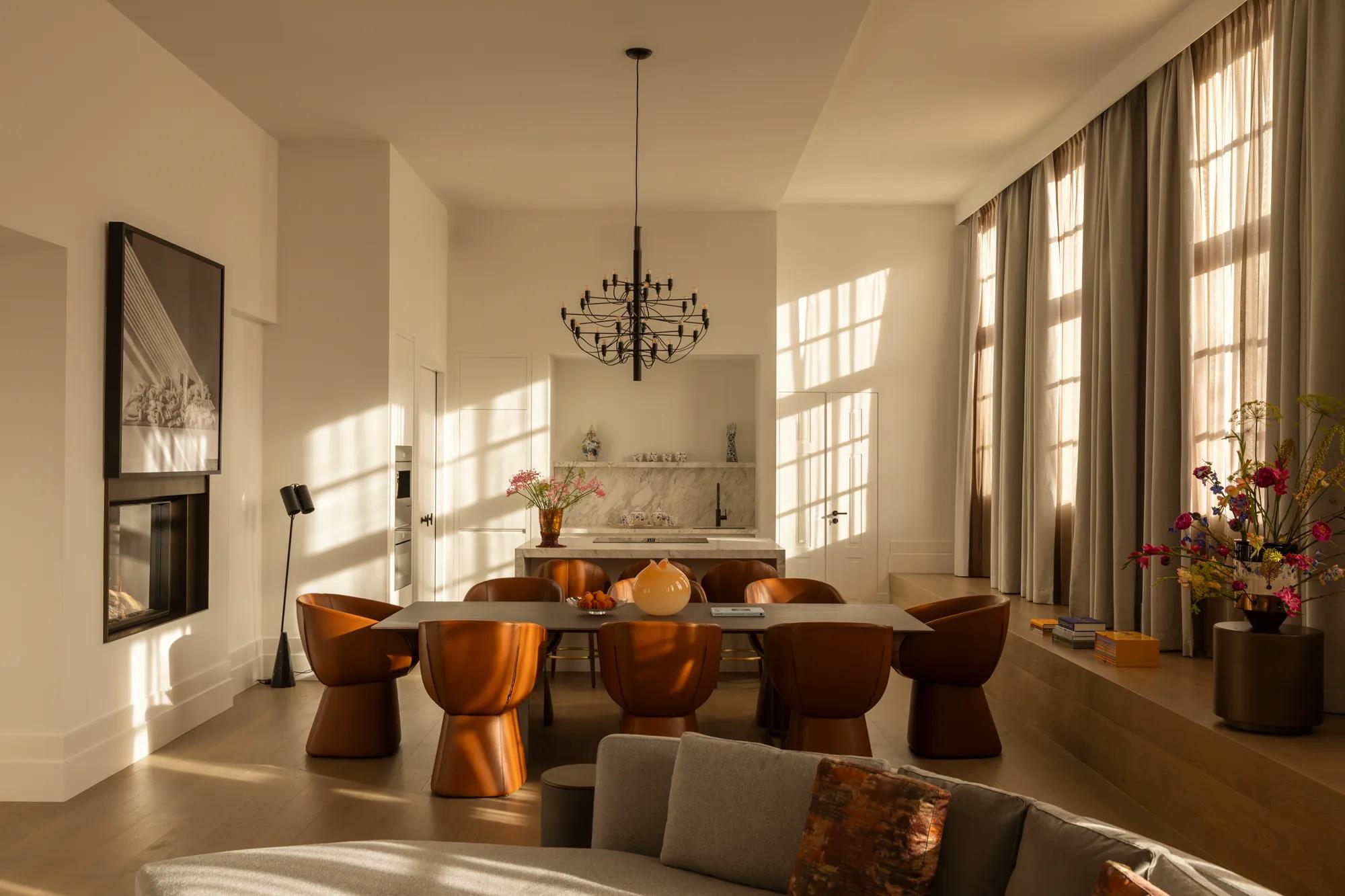 Rosewood Amsterdam: the dining room and kitchen of Huis 020 with leather chairs and a black chandelier