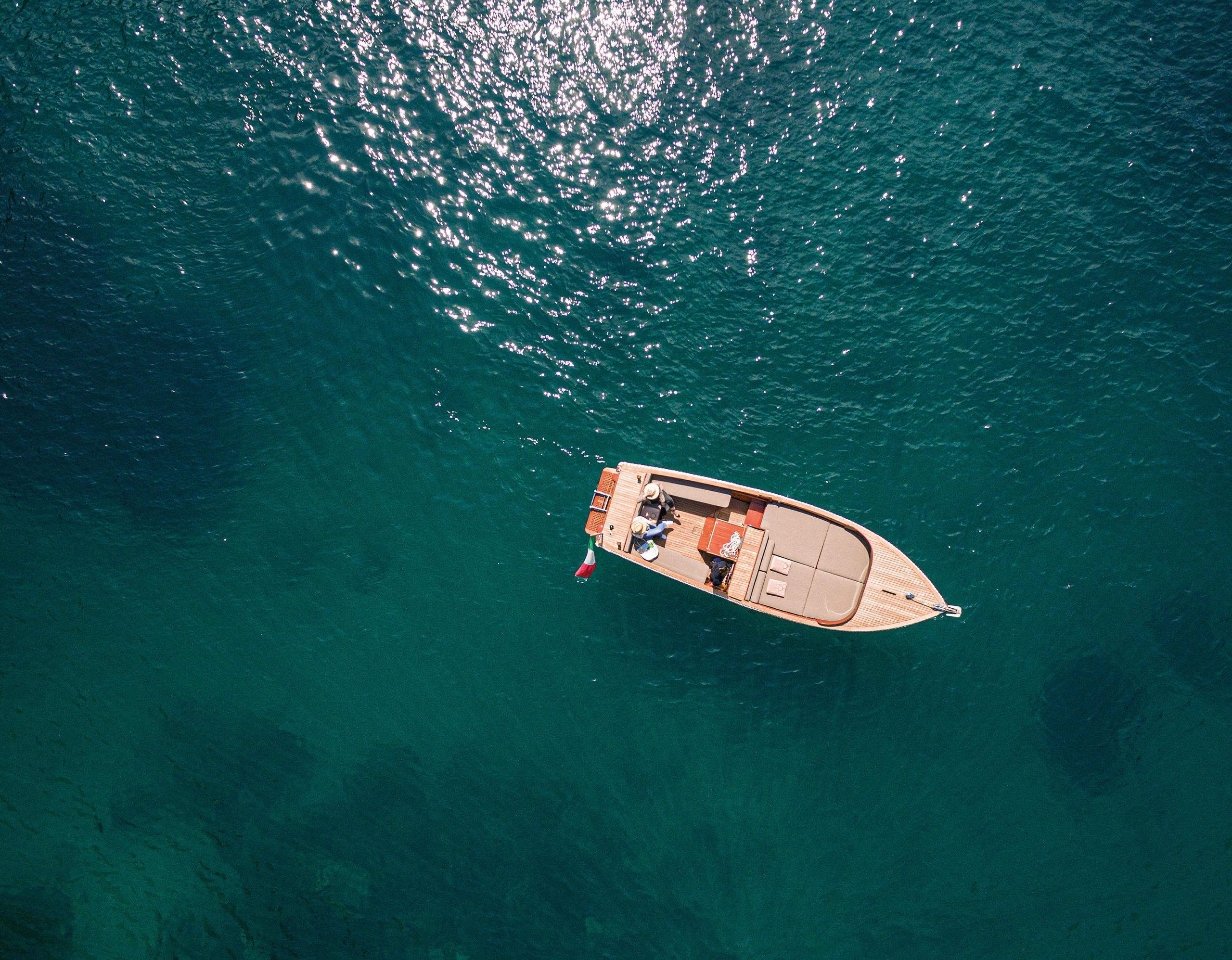 A small motorboat anchored in calm turquoise Mediterranean waters