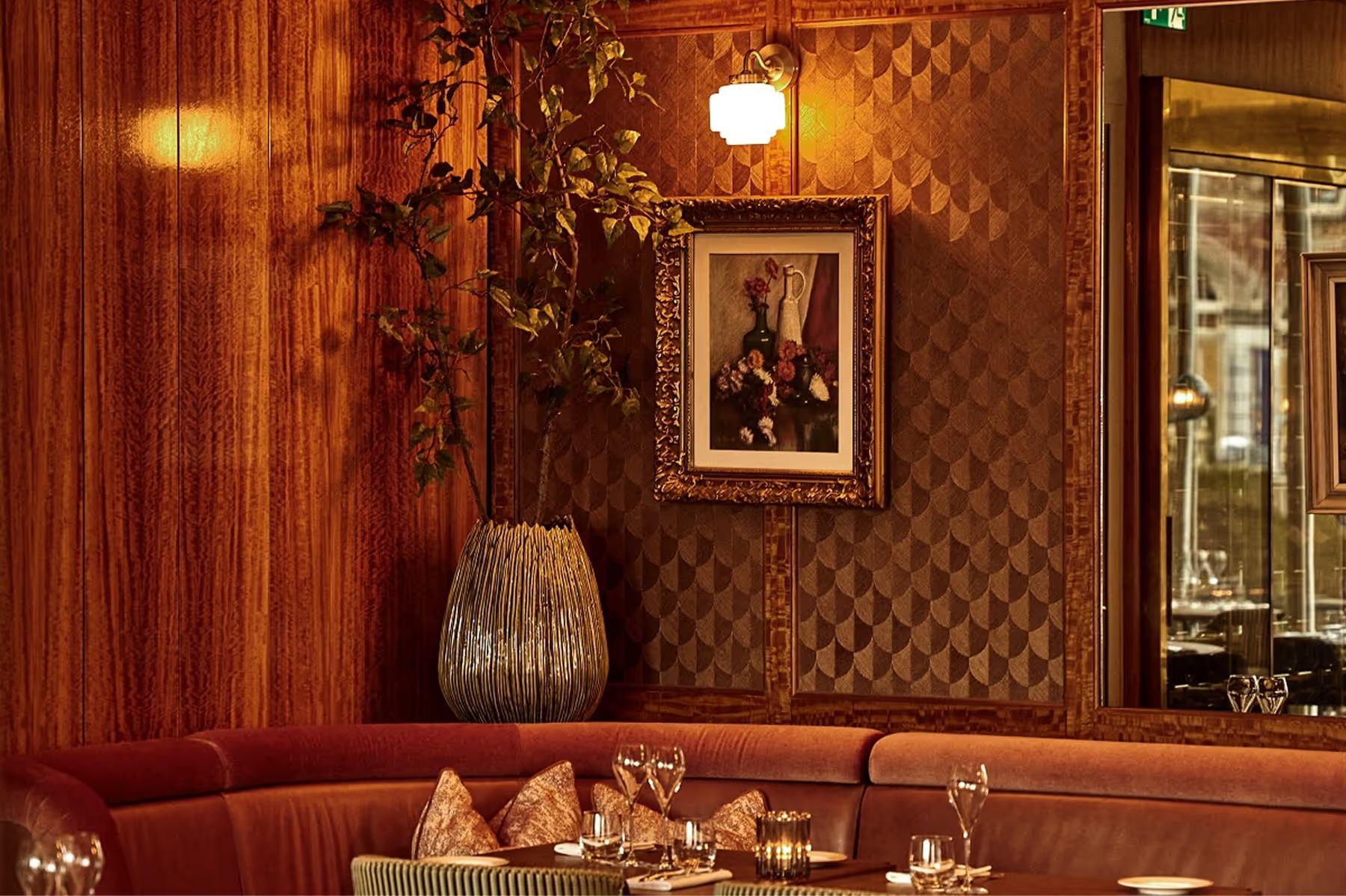 Intimate bar area with mirrored walls, warm wood paneling, and ornamental details
