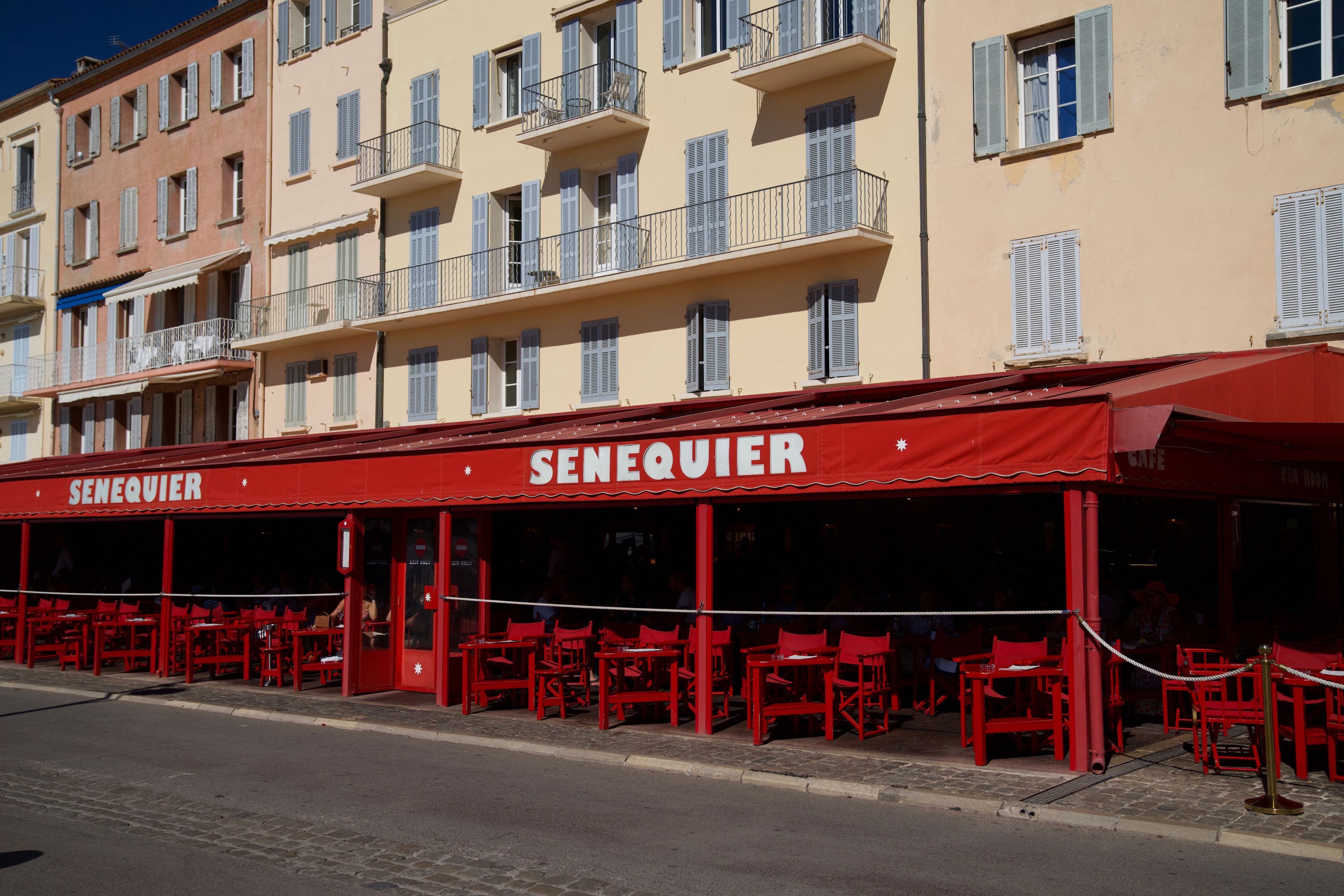 The red Sénéquier cafe beneath pastel facades in Saint-Tropez