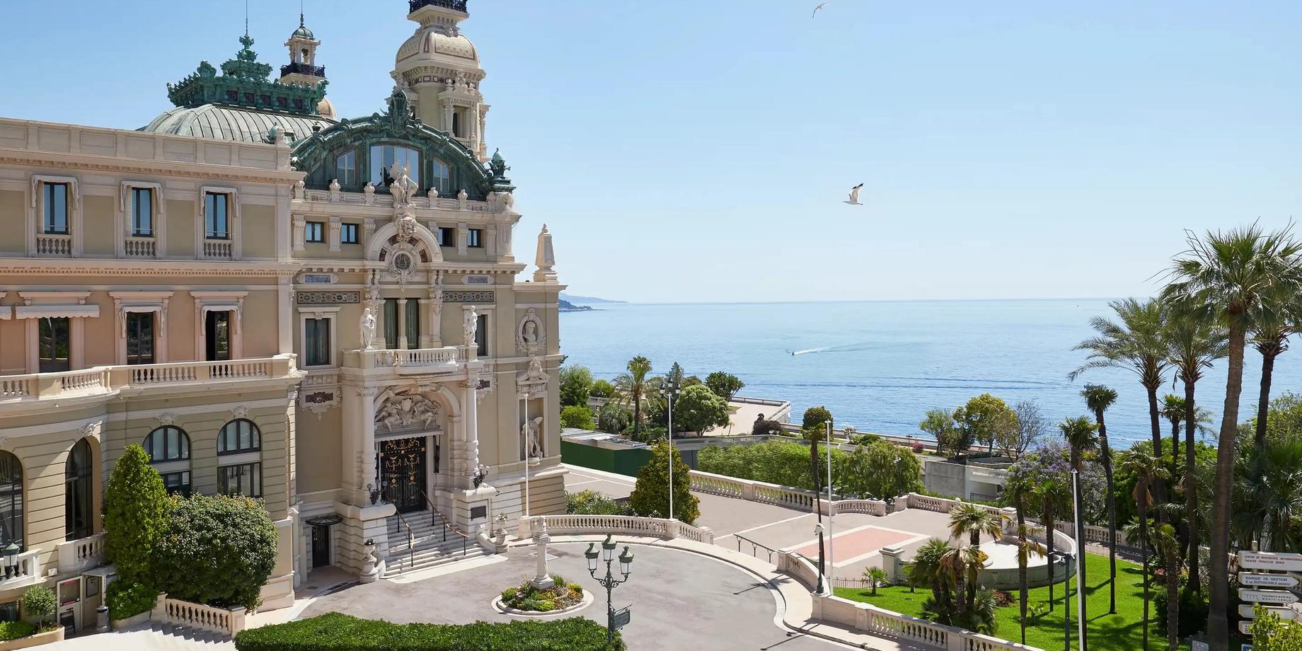 Beige palazzo facade with towers overlooking the Mediterranean and palm trees