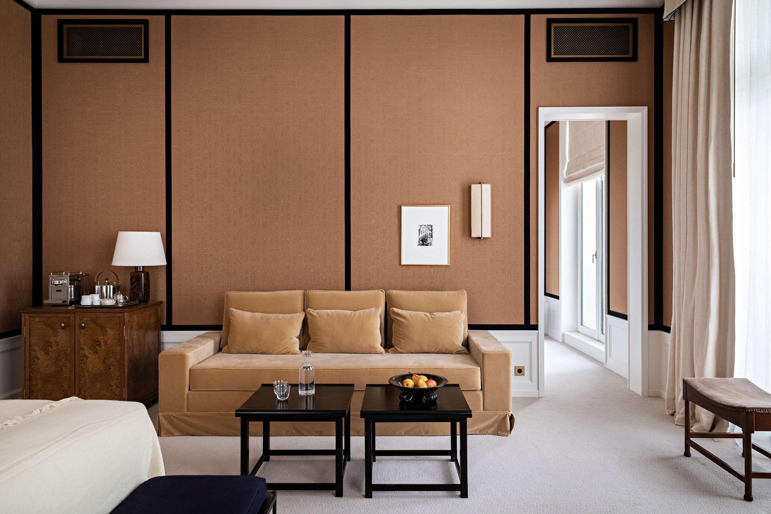 Hôtel Balzac: a bedroom with tan paneling, a bench at the foot of the bed, and wood accents